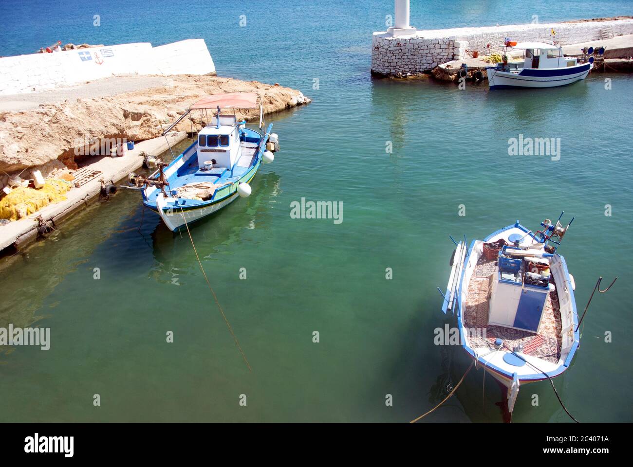 The old harbor on the quiet Greek island of Kasos. Traditional fishing boats moored in sheltered waters.  A peaceful, untroubled scene, little changed Stock Photo