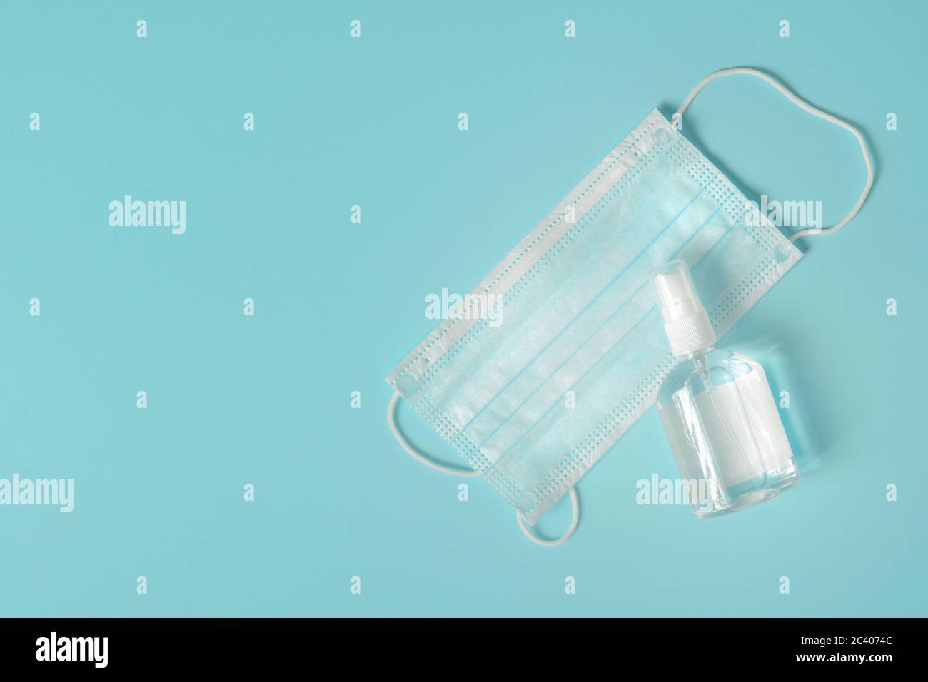 Disinfection gel and protective surgical mask on blue background with copy space, top view flat lay Stock Photo