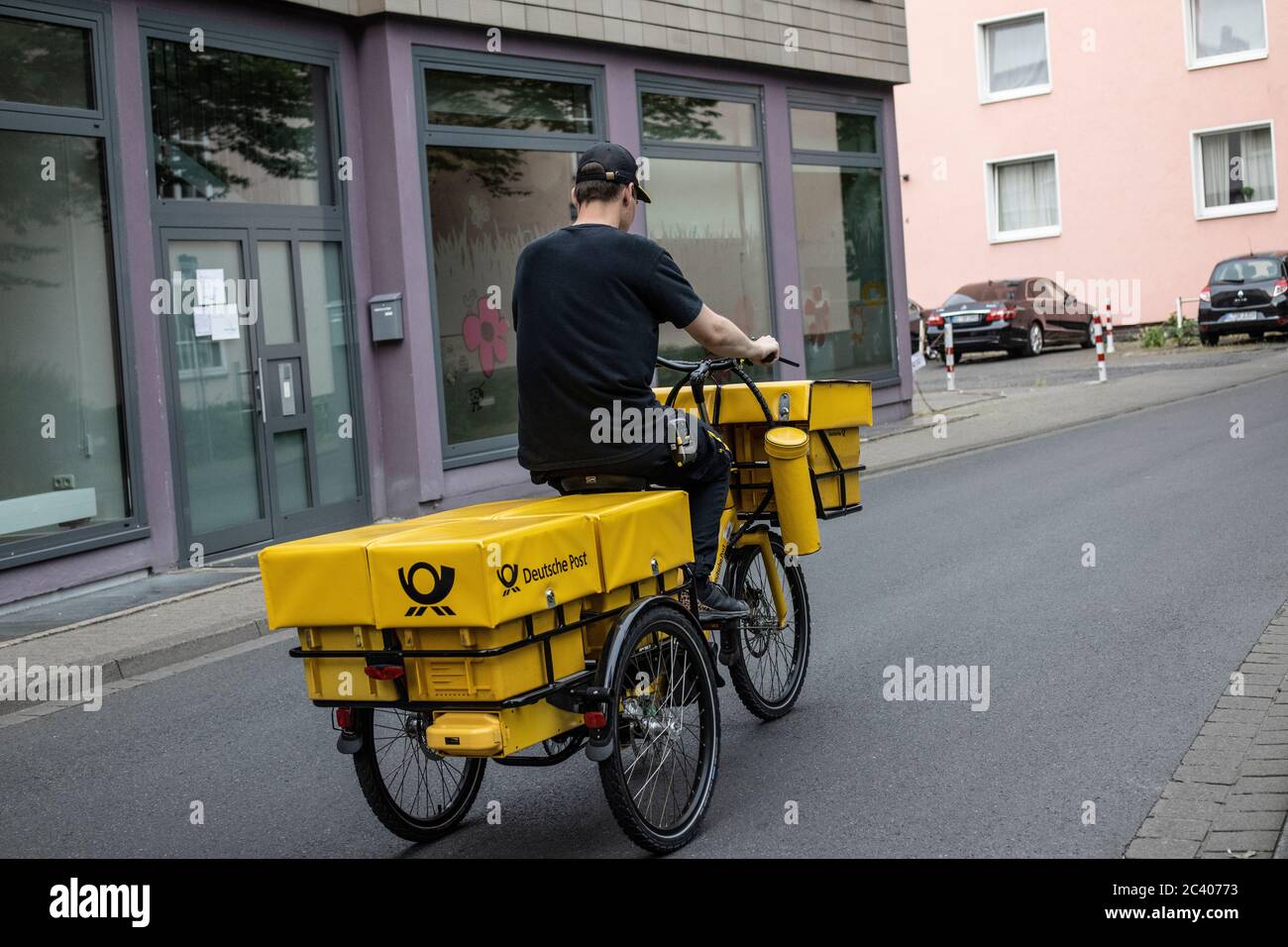 Postal worker delivering his round on his bicycle, Hannover, Germany Stock Photo