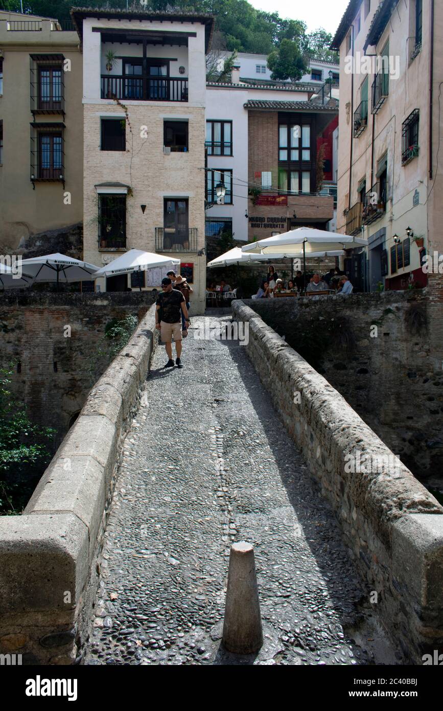 Beautiful, historic Granada city Spain. View along a charming, old, Moorish footbridge the Puente Espinosa, in the old town to cafes and restaurants. Stock Photo