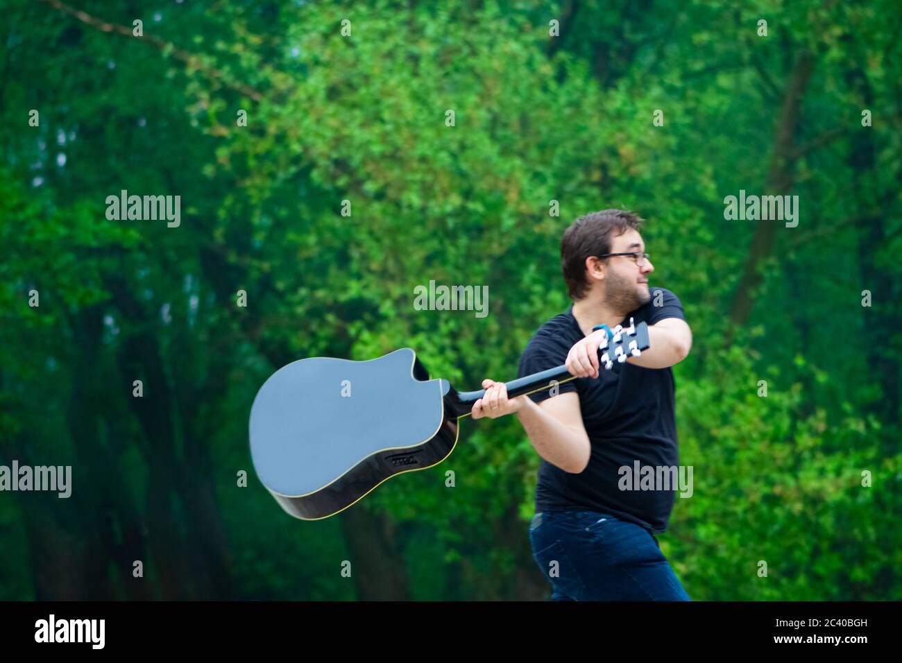 Upset man breaking acoustic guitar in the nature Stock Photo