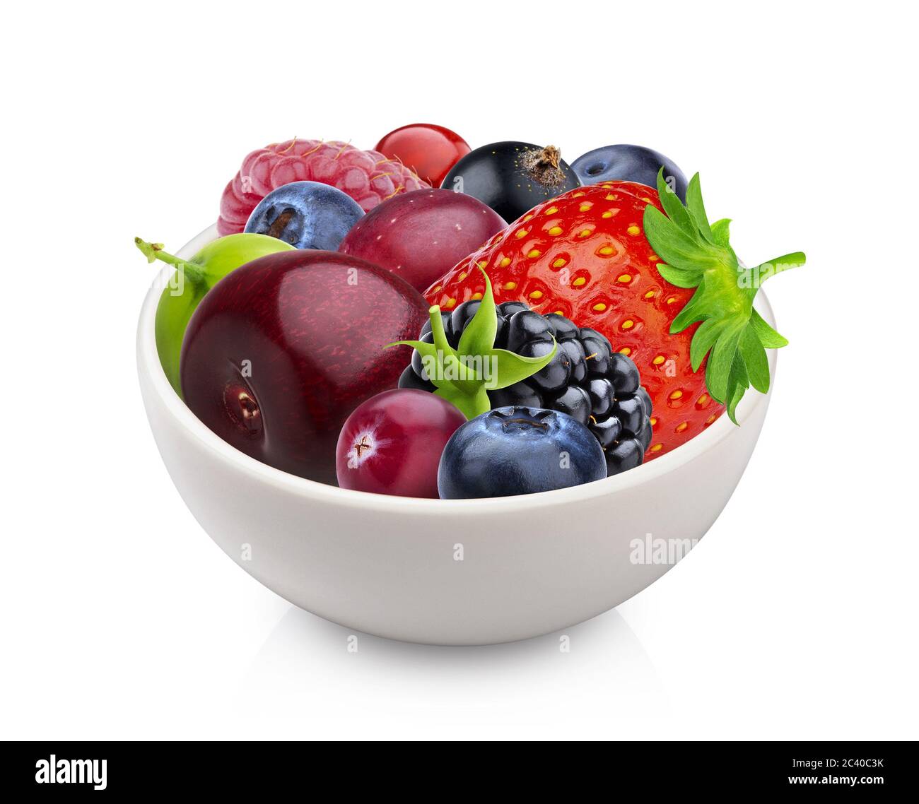 Pile of different forest berries in bowl isolated on white background Stock Photo