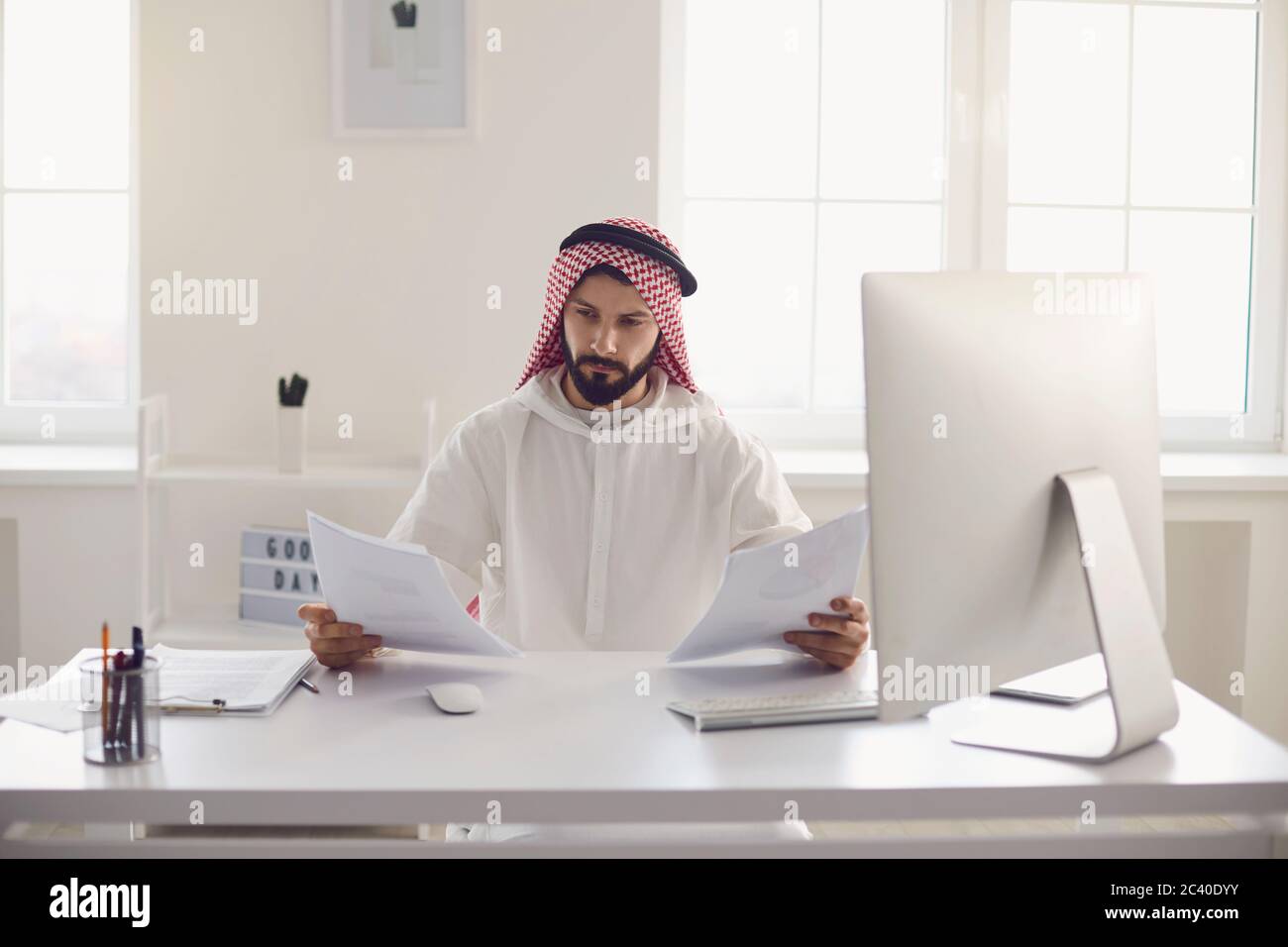 Serious Arabian businessman working with documents in office Stock Photo
