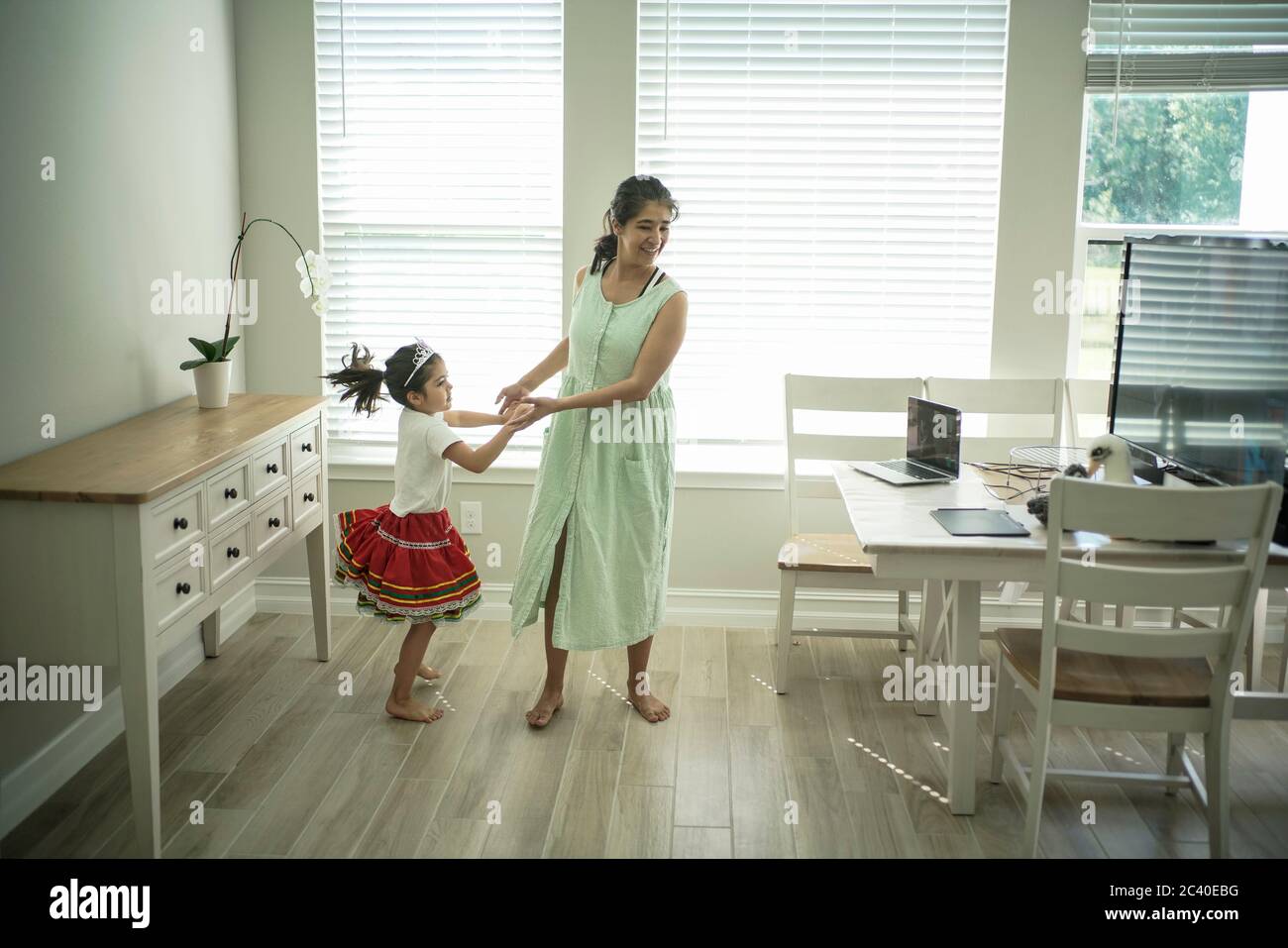 Girl enjoys an online dance class with a laptop connected to a TV at home Stock Photo