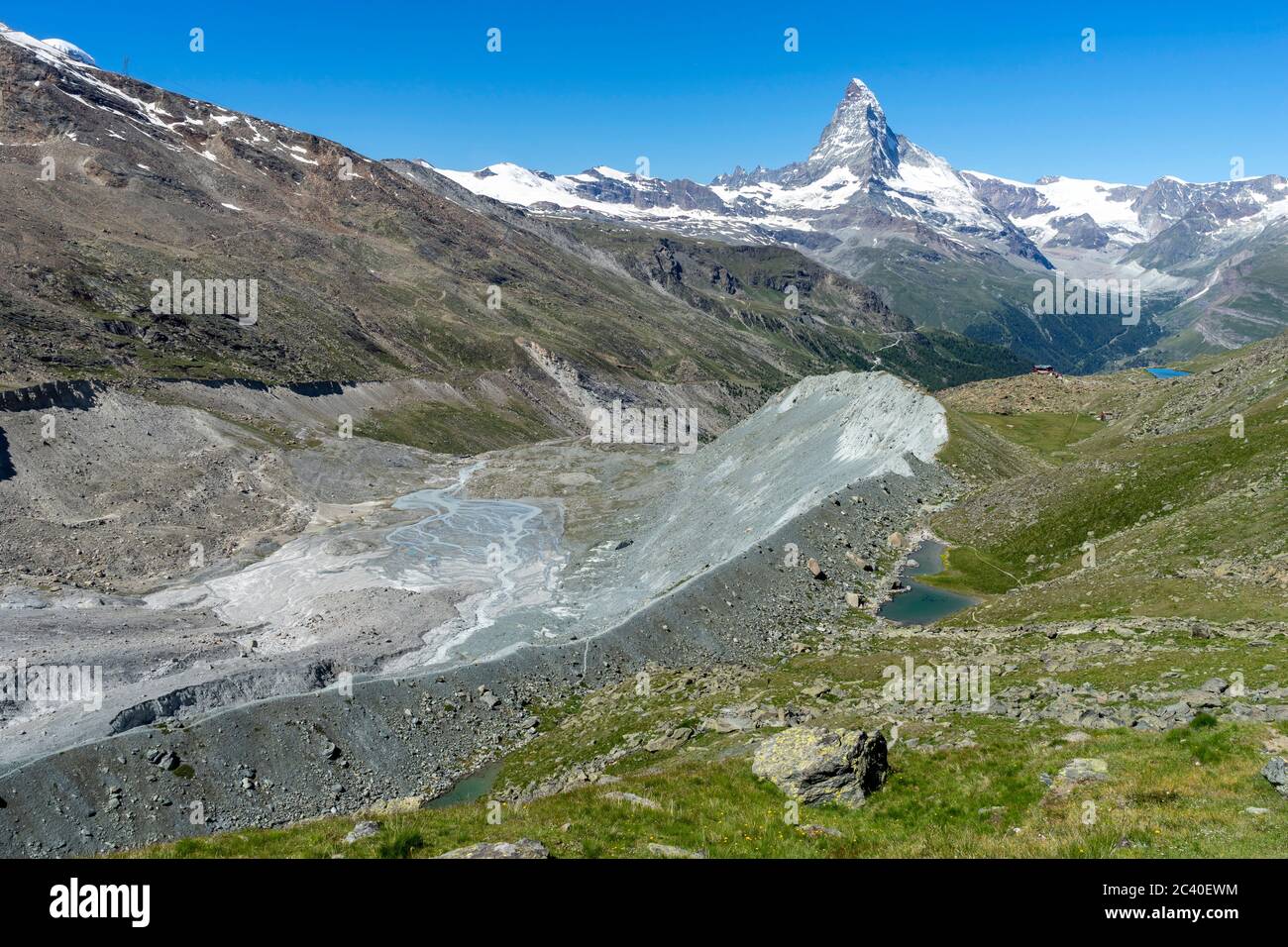 Die Fluhalp und das Berghaus Fluhalp neben der Moräne des zurückschmelzenden Findelgletschers. Darüber das Matterhorn. Rechts des Berghauses der Stell Stock Photo