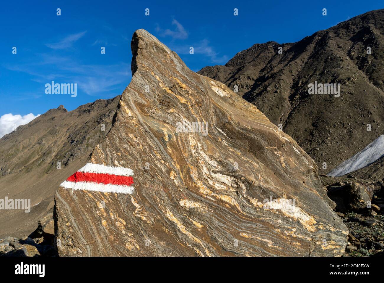 Farbmarkierung eines Bergwanderwegs auf einem gebänderten Felsblock im Val Corno, Kanton Tessin. Stock Photo