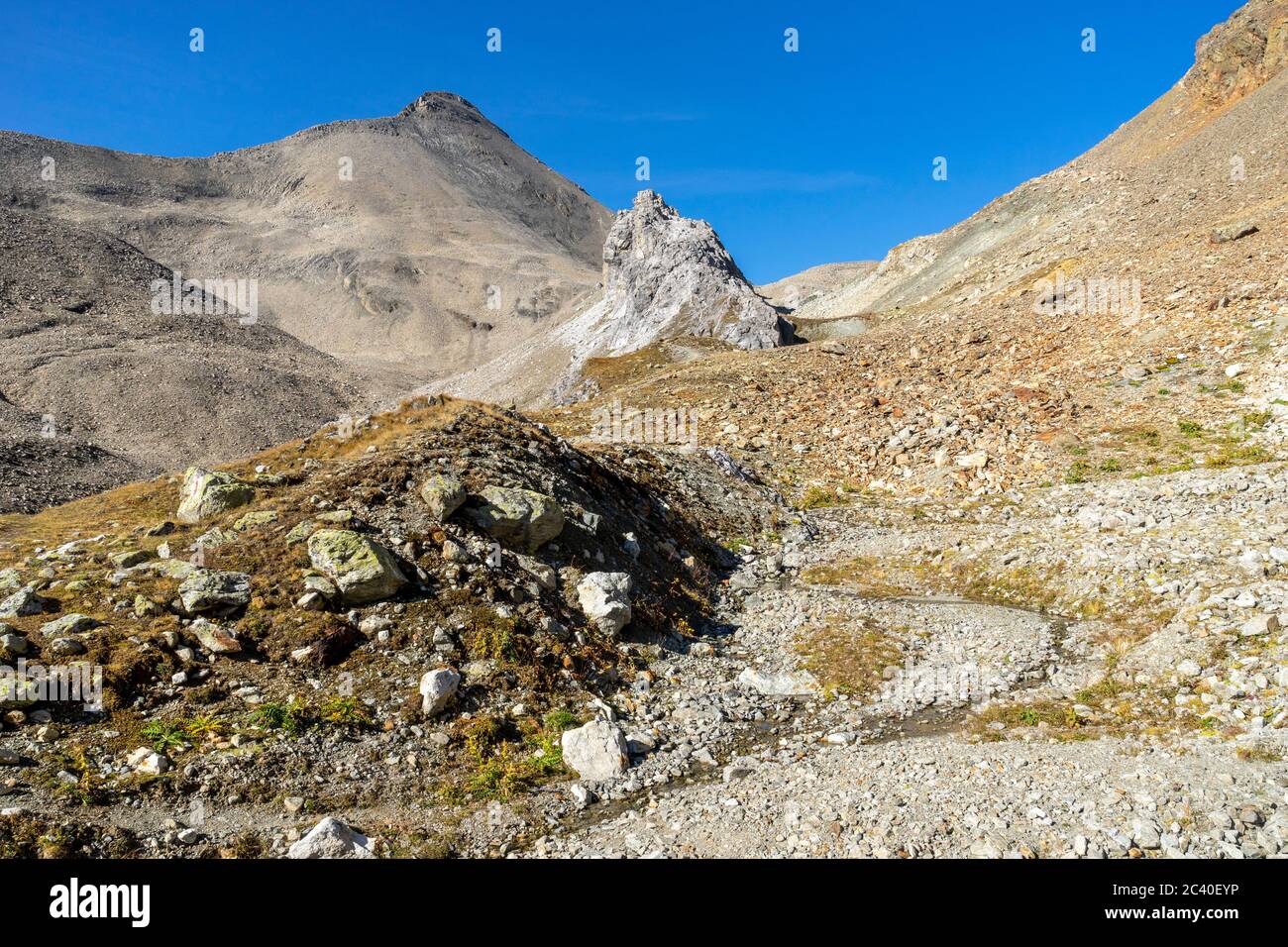 Der Piz Blaisun (Kalkgestein) zuhinterst im Val d'Es-cha. Im Tal eine graue Formation aus Rauwacke und Dolomit-Gestein. Stock Photo