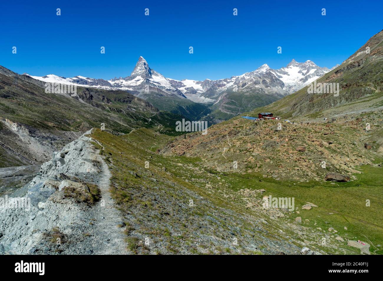 Auf der Moräne des Findelgletschers. Das Berghaus Fluhalp mit dem Stellisee, bei Zermatt, Kanton Wallis. Matterhorn, Dent Blanche, Obergabelhorn, Well Stock Photo