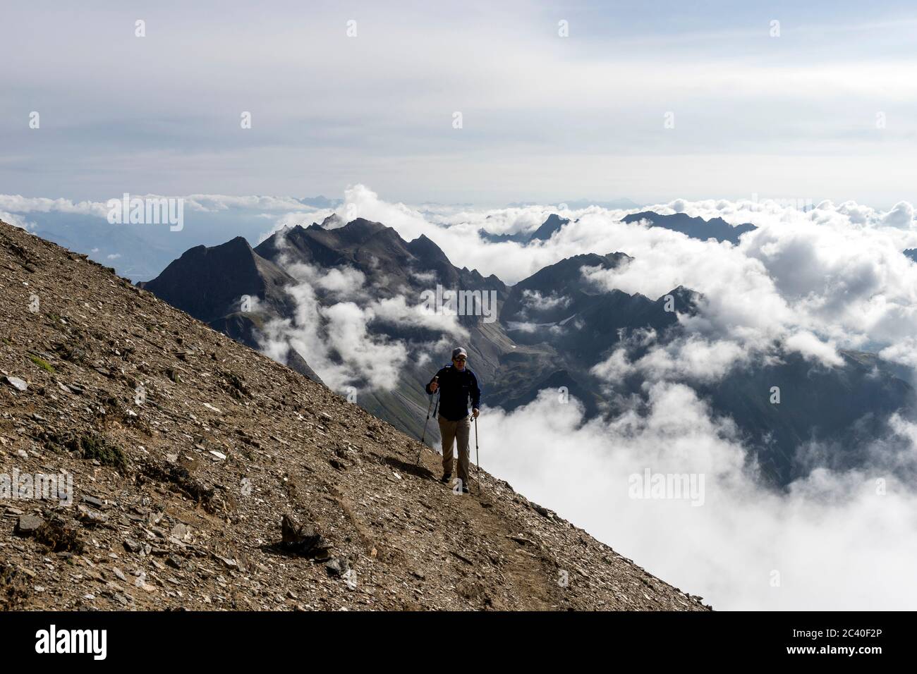 Bergwanderer unter dem Gipfel des Bättelmatthorns auf der Grenze Italien-Wallis. Nufenen-Region, Kanton Wallis. (model release) Stock Photo