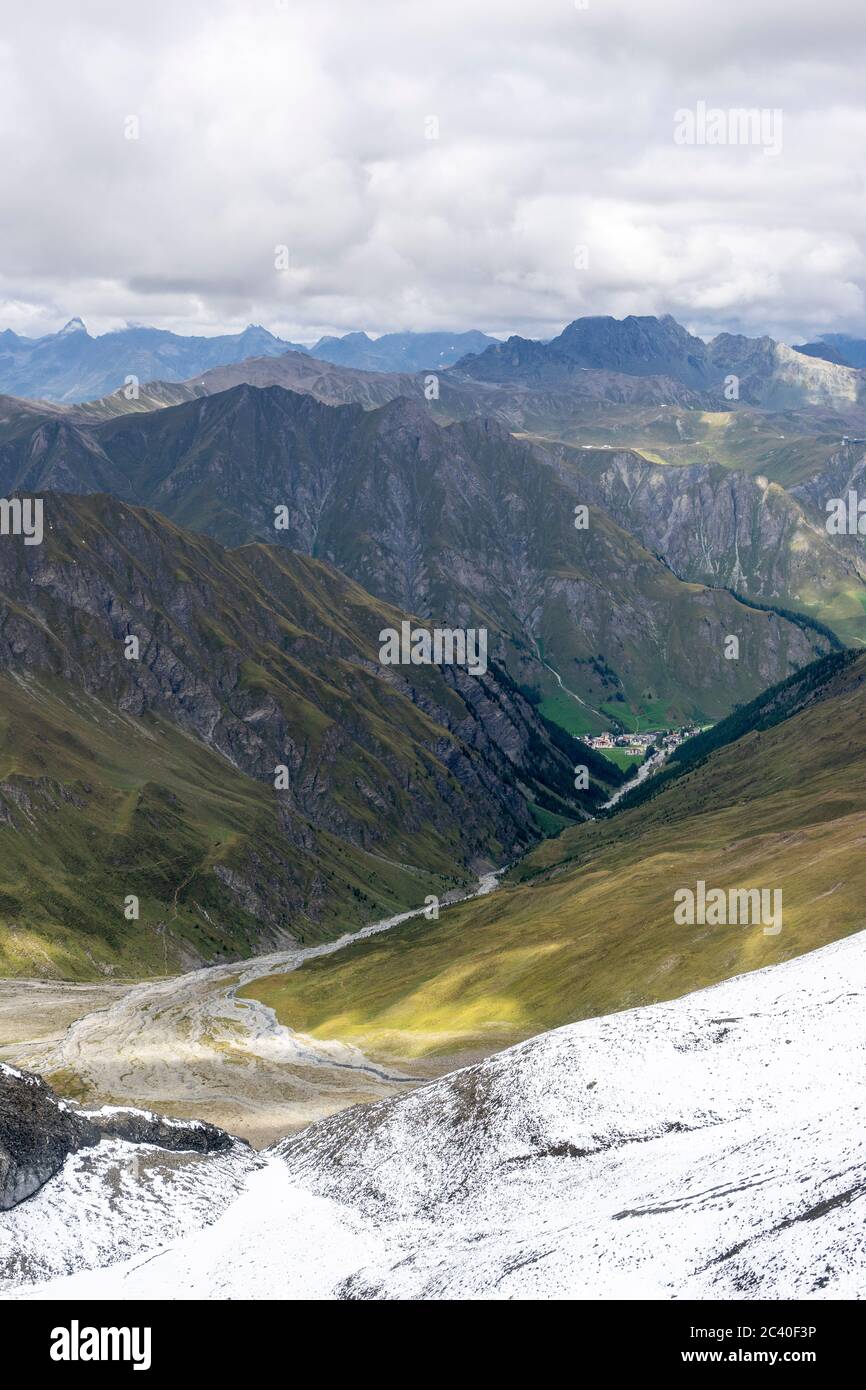 Sicht vom Muttler durch das Val Maisas zum Dorf Samnaun, Unterengadin, Kanton Graubünden. Über dem Dorf am Horizont der Bürkelkopf auf der Grenze Schw Stock Photo