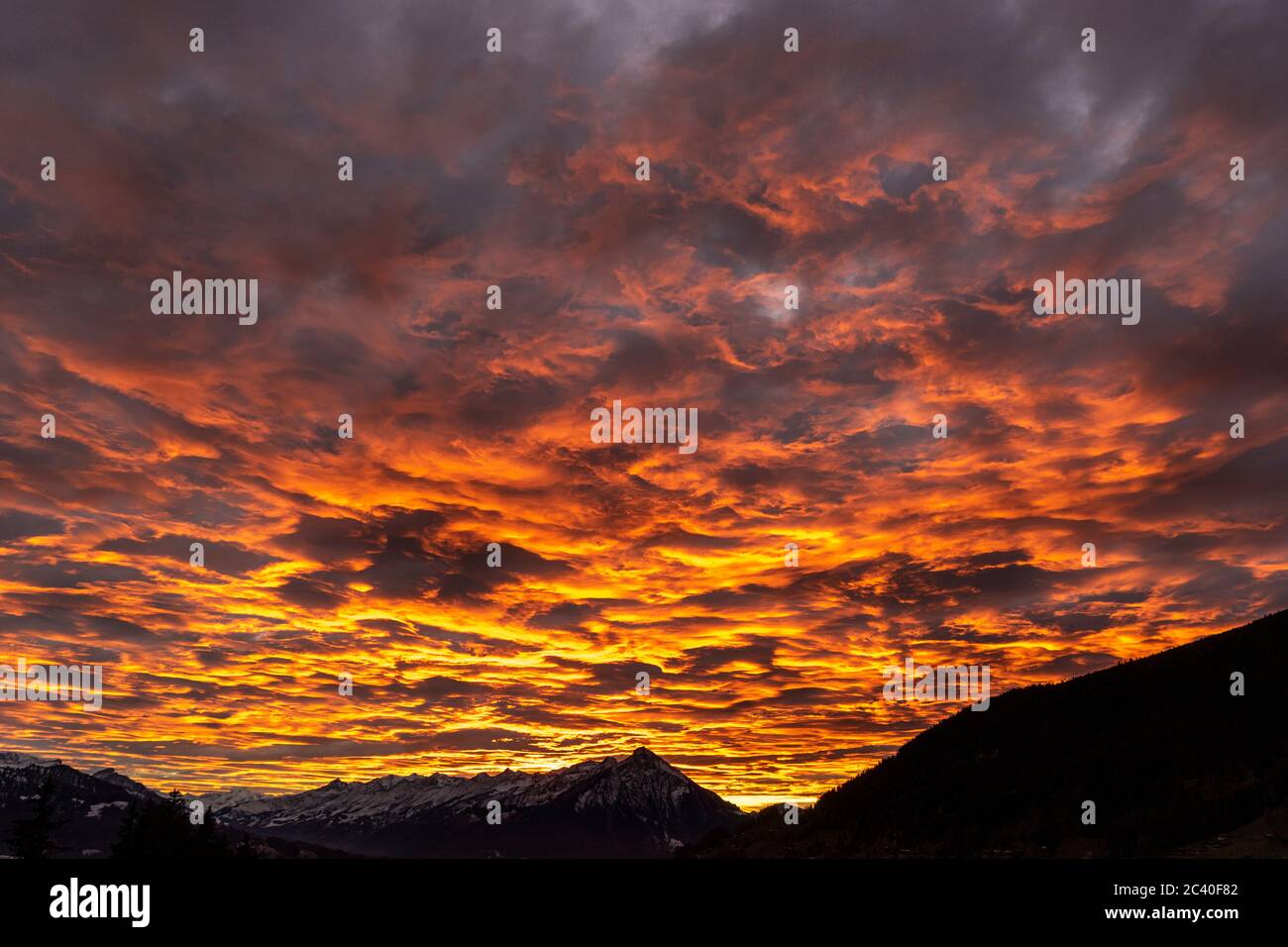 Die untergehende Sonne beleuchtet die Wolken über dem Niesen im Berner Oberland. Sicht von Beatenberg. Stock Photo