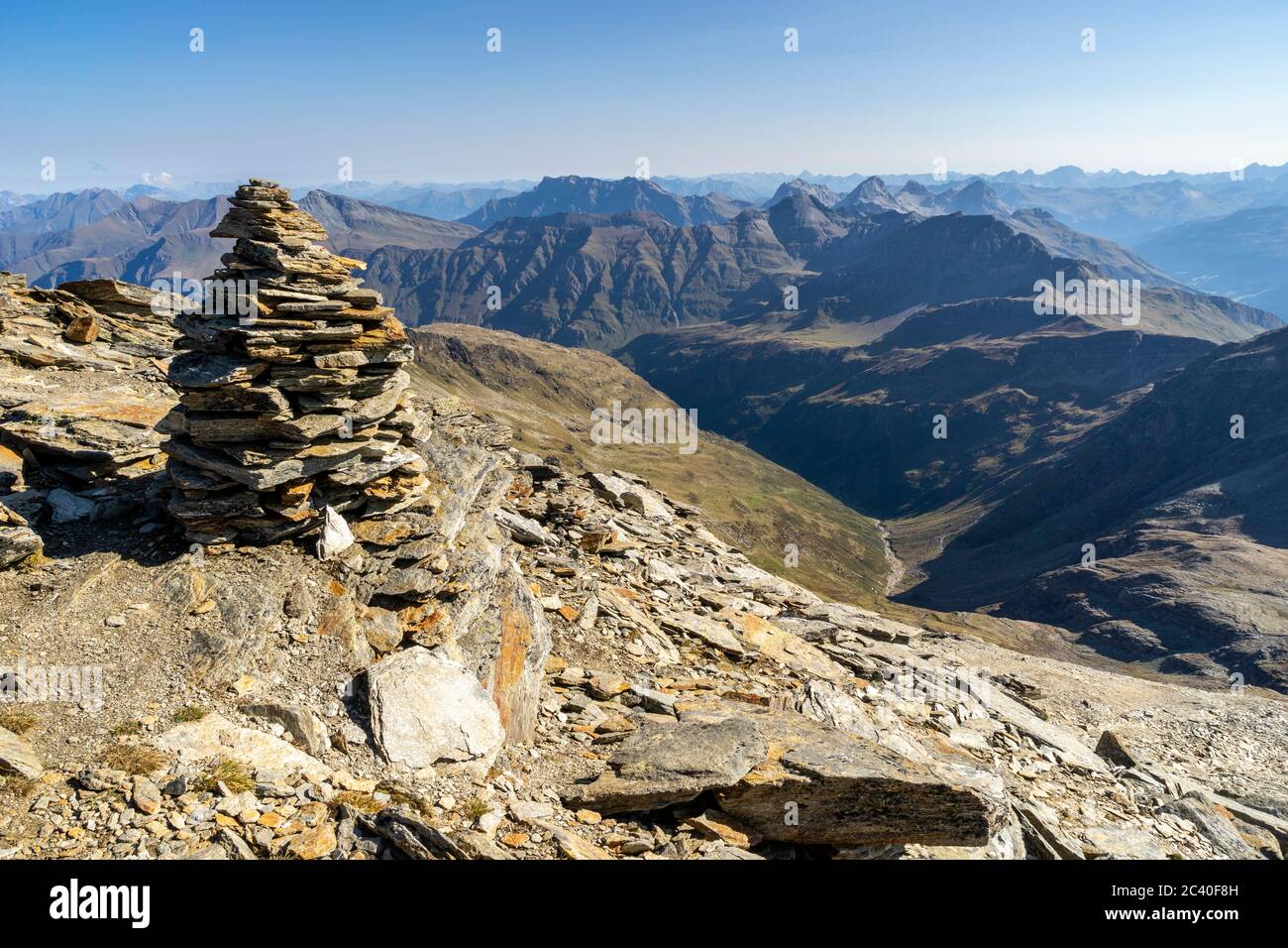 Steinmann auf dem Gipfel des Fanellhorns, Zervreila-Region, Valser Tal, Graubünden. Sicht hinunter ins Tal namens Peil. Über dem Peil im Schatten das Stock Photo