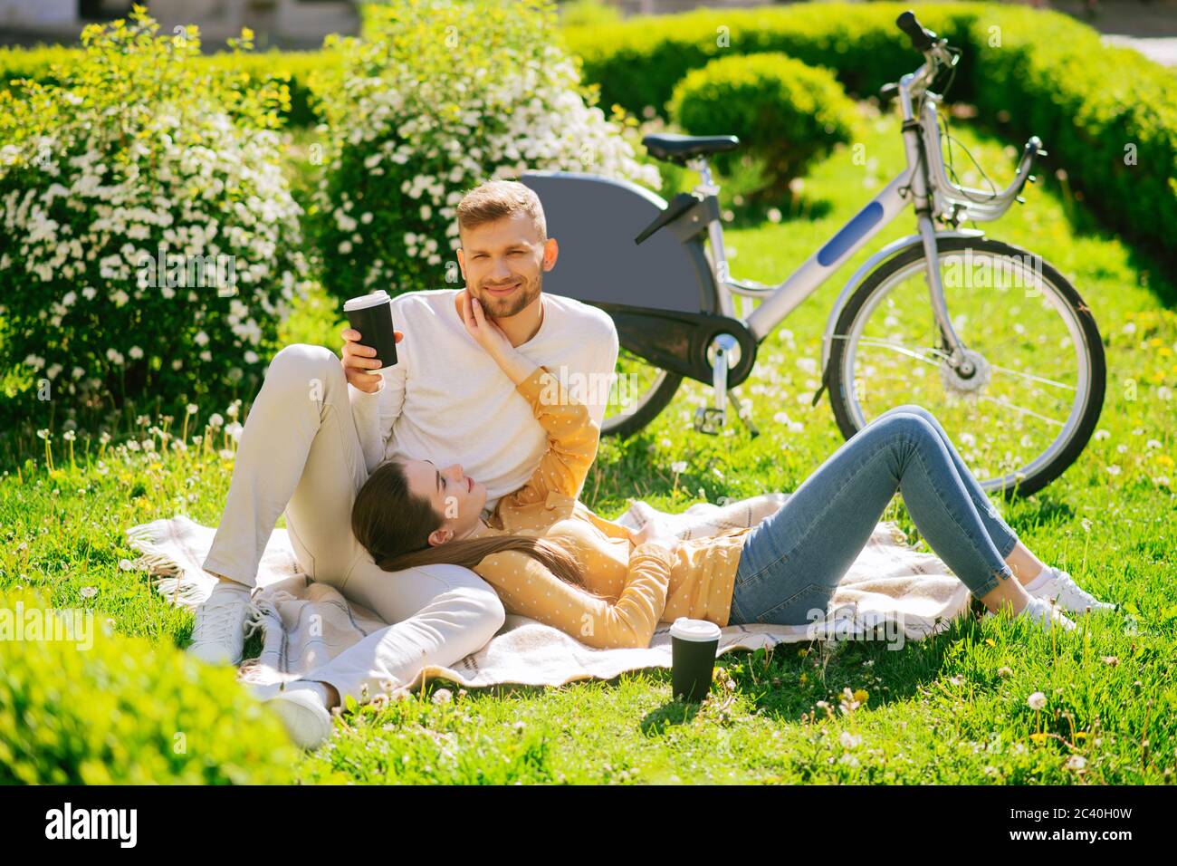 Young couple man and woman resting on plaid on the grass Stock Photo