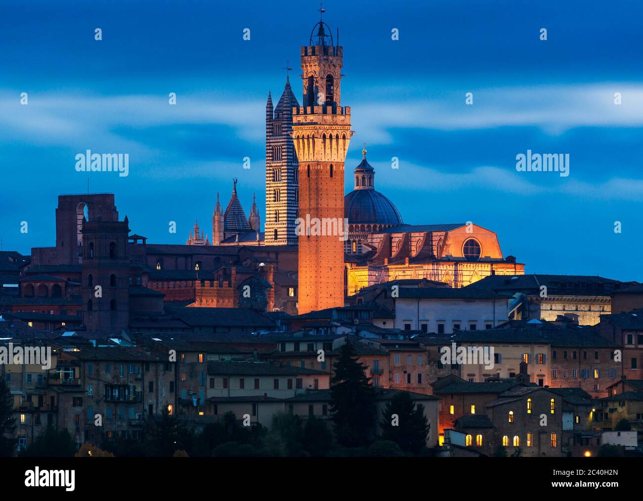 the skyline of Siena, Italy, shot at dusk with its famous tower in the foreground Stock Photo