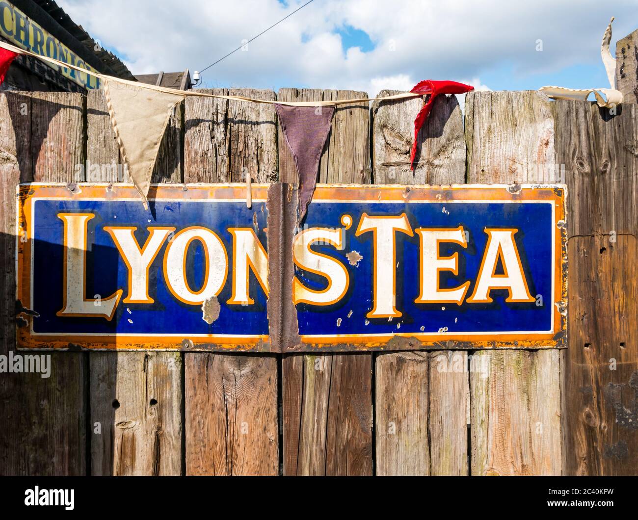 Old fashioned vintage Lyons' Tea advertising sign on wooden fence, England, UK Stock Photo