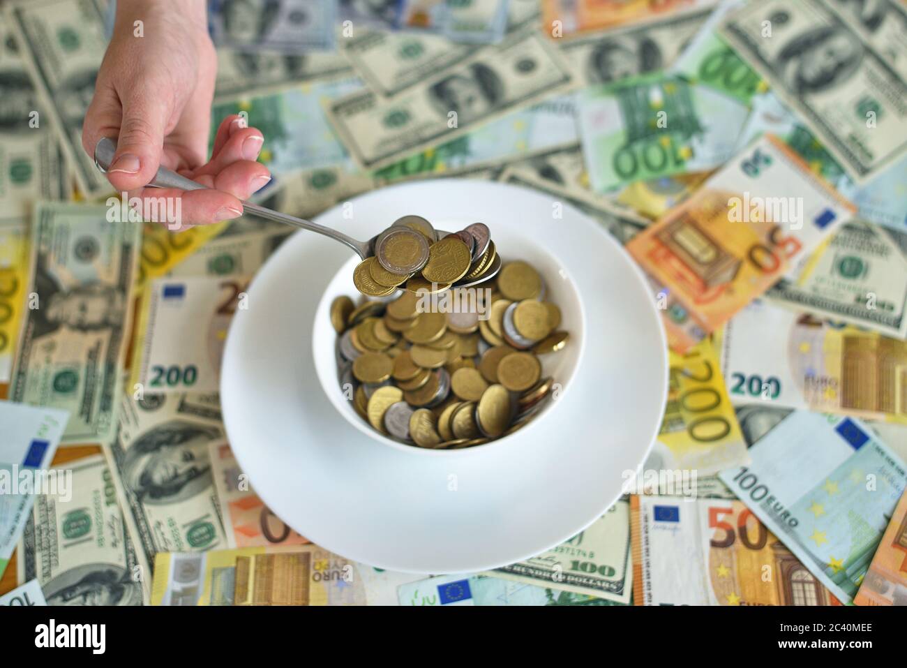 plate with coins. euro and dollar bills on the table Stock Photo
