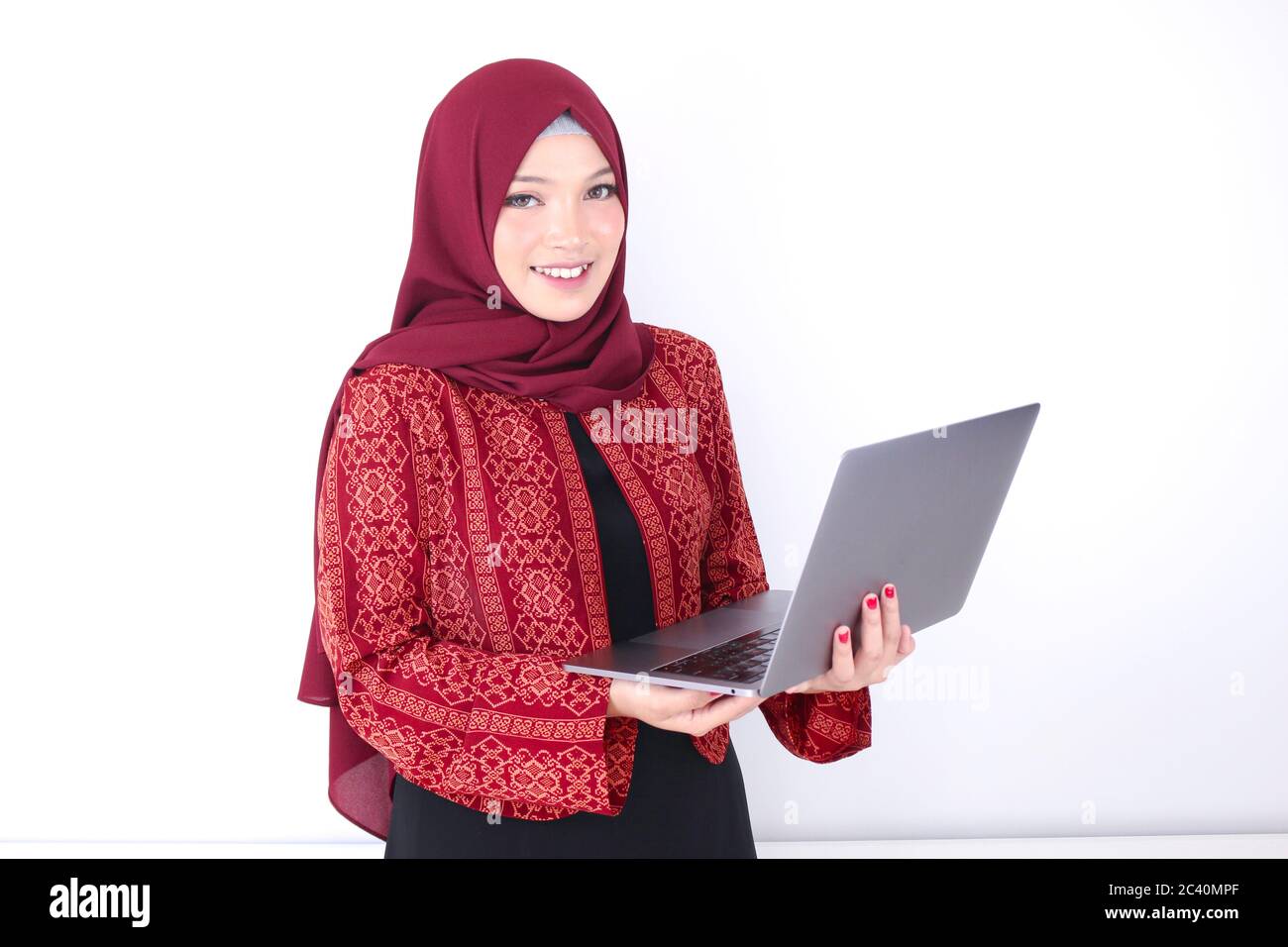Young Asian Islam woman is standing and smiling face with hand holding ...