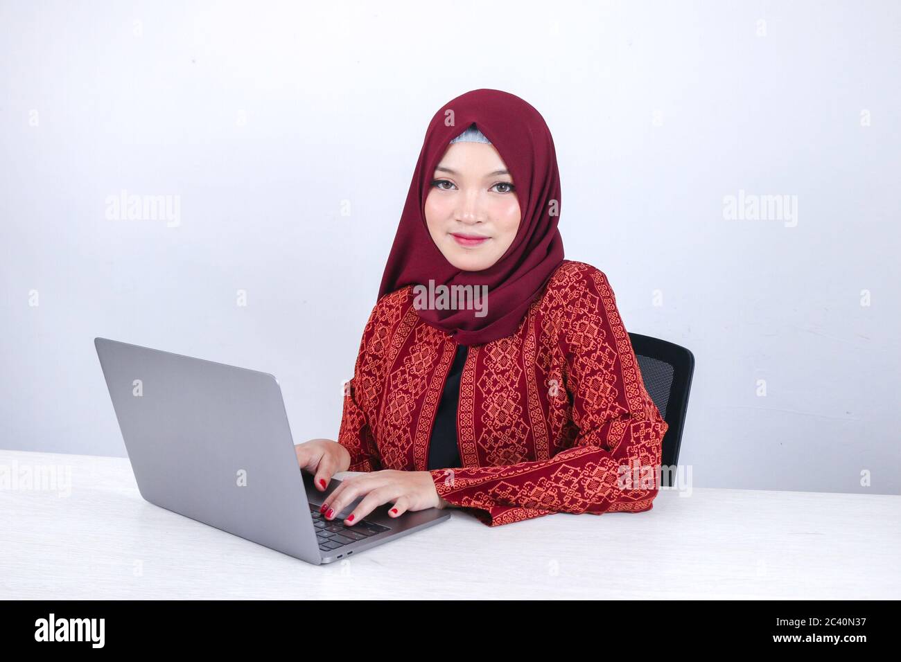 Young Asian Islam woman is sitting enjoy and smiling when working on ...