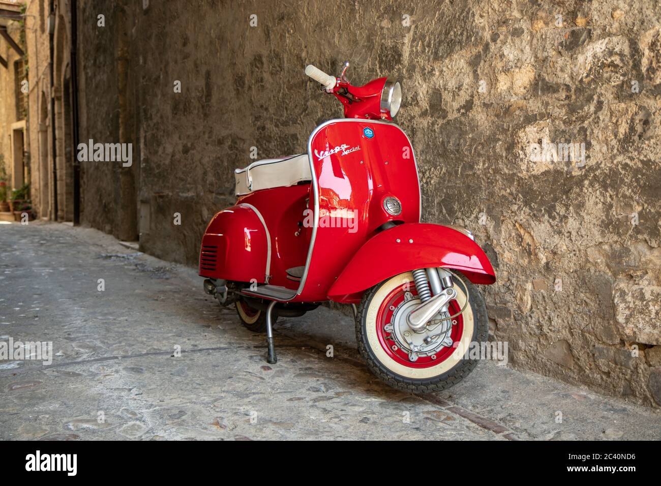 June 30, 2019 - Rome, Lazio, Italy - A red Piaggio Vespa Sprint, parked in an alleyway of an ancient village, in Italy. The scooter symbol of Italian Stock Photo