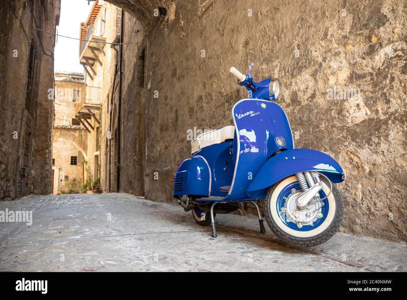 June 30, 2019 - Rome, Lazio, Italy - A blue Piaggio Vespa Sprint, parked in an alleyway of an ancient village, in Italy. The scooter symbol of Italian Stock Photo