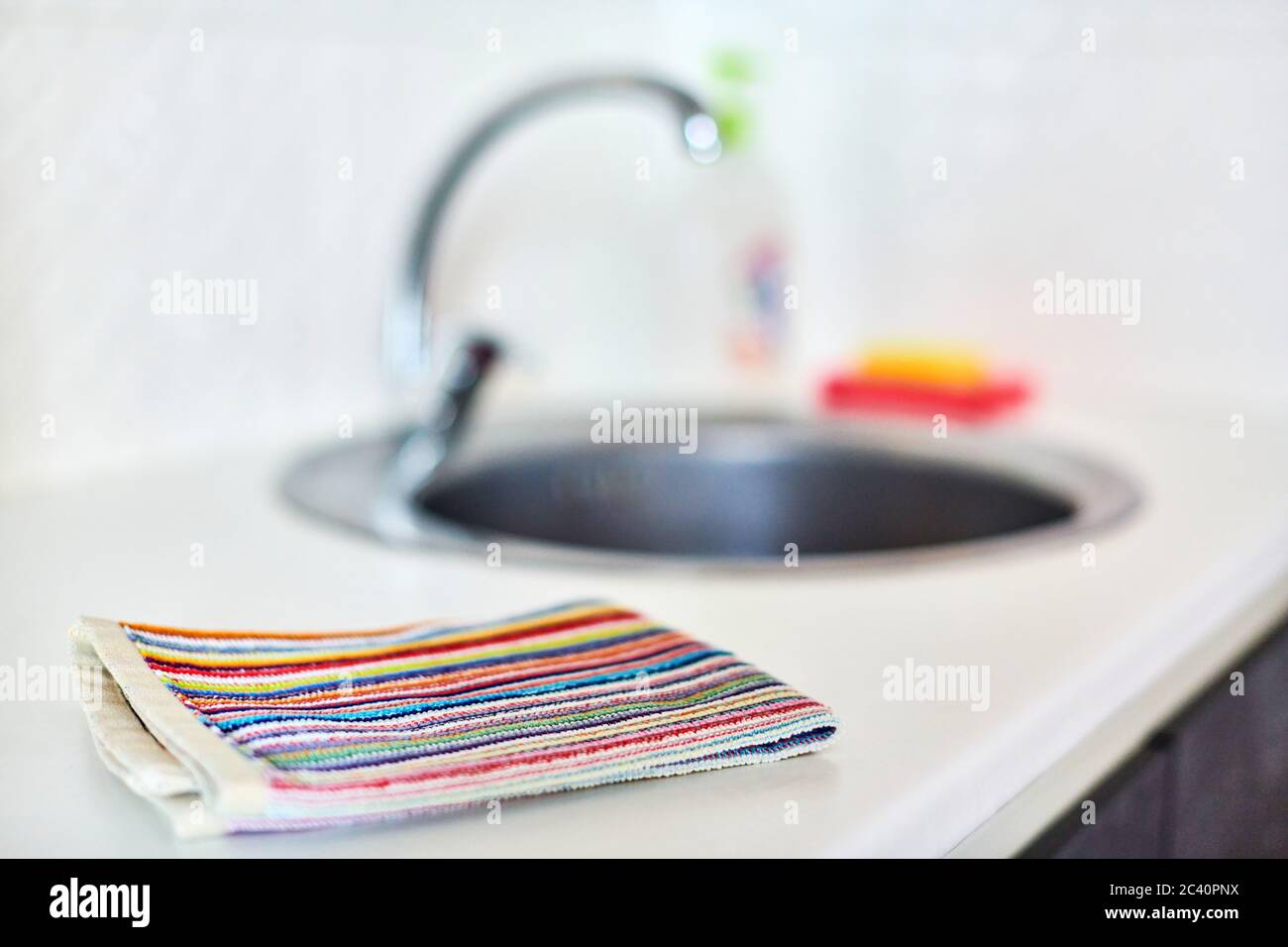 Kitchen towel and sink without dirty dishes background. Dishcloth on kitchen countertop. Cleaning and dish washing concept. Stock Photo