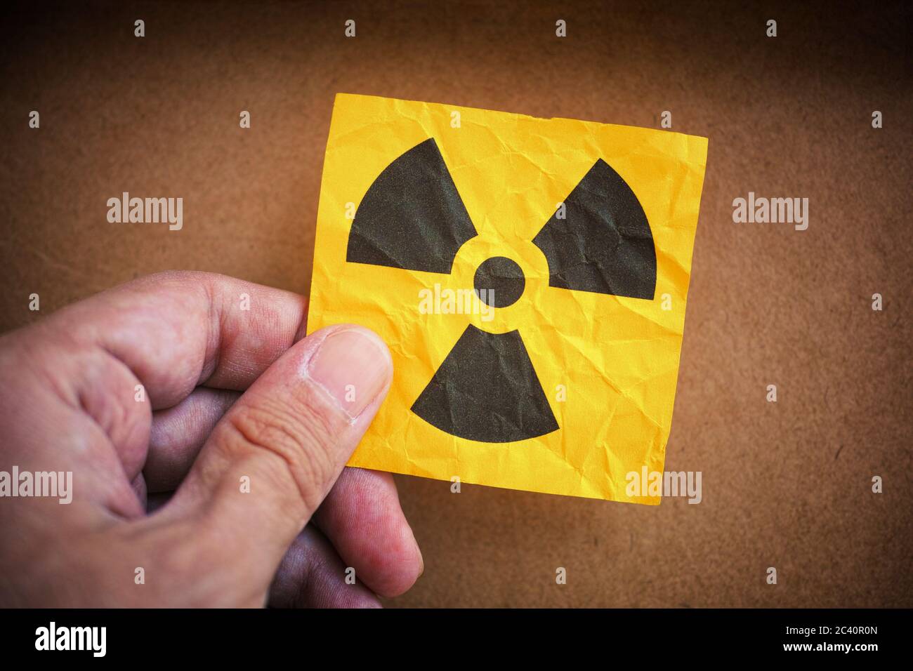 Man holding radiation warning sign in his hand. Close up. Stock Photo