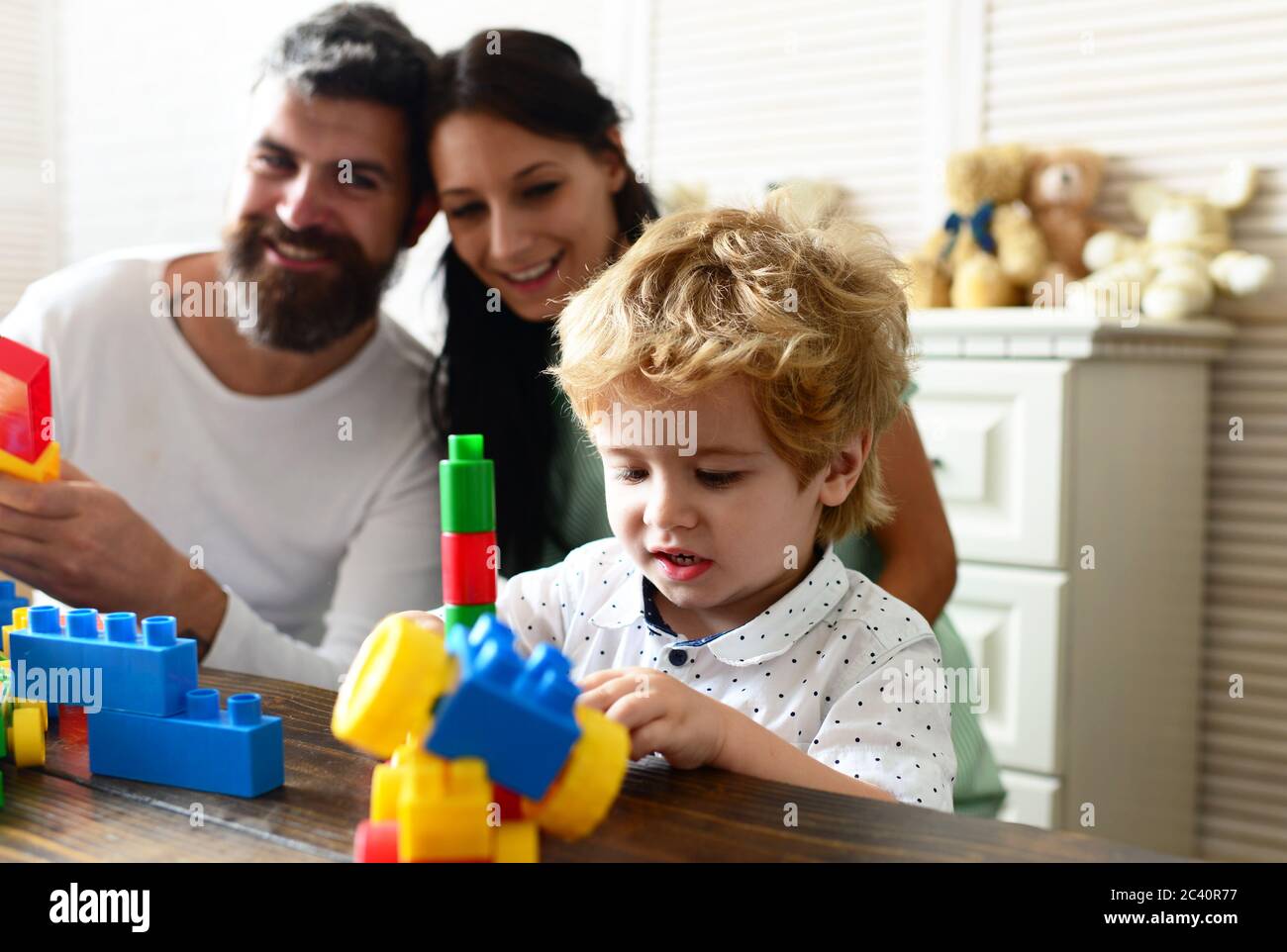 Mom, dad and boy on light background build out of plastic blocks ...