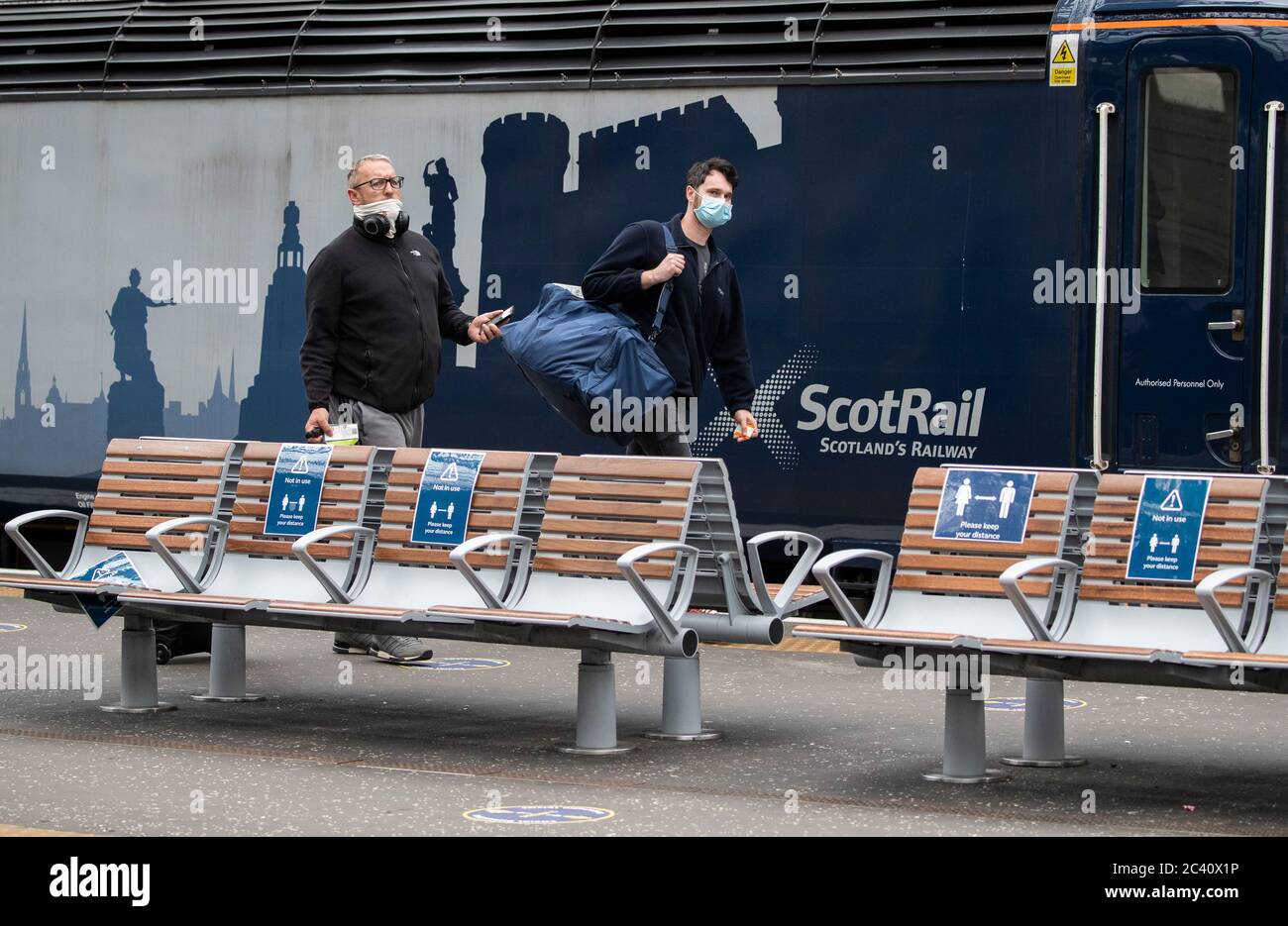 Members of the public wear protective face masks inside Waverley Station, Edinburgh, as Scotland moves into the second phase of its four-step plan to ease out of lockdown. Stock Photo