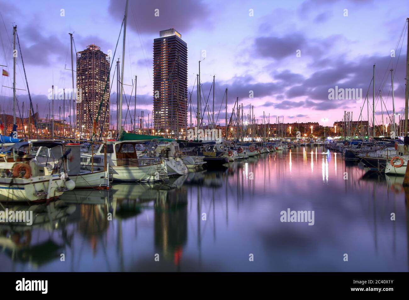 Twin skyscrapers towering over the marina in Port Olimpic (Olympic Harbor), Barcelona, Spain at sunset. Stock Photo