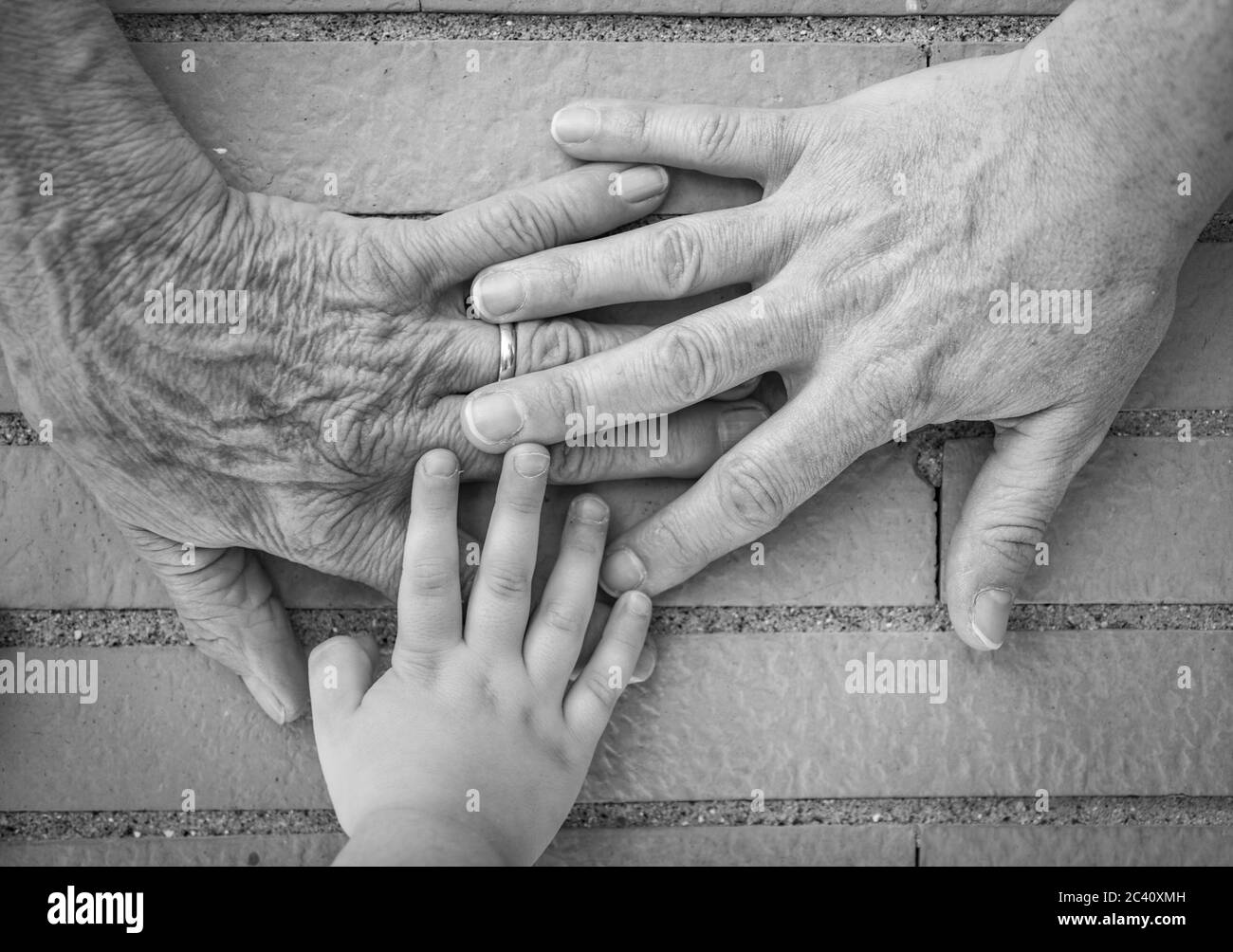 Three hands together, grandmother (elderly woman), mother, daughter, granddaughter. Family unity, love, help, assistance. Age and generational differe Stock Photo