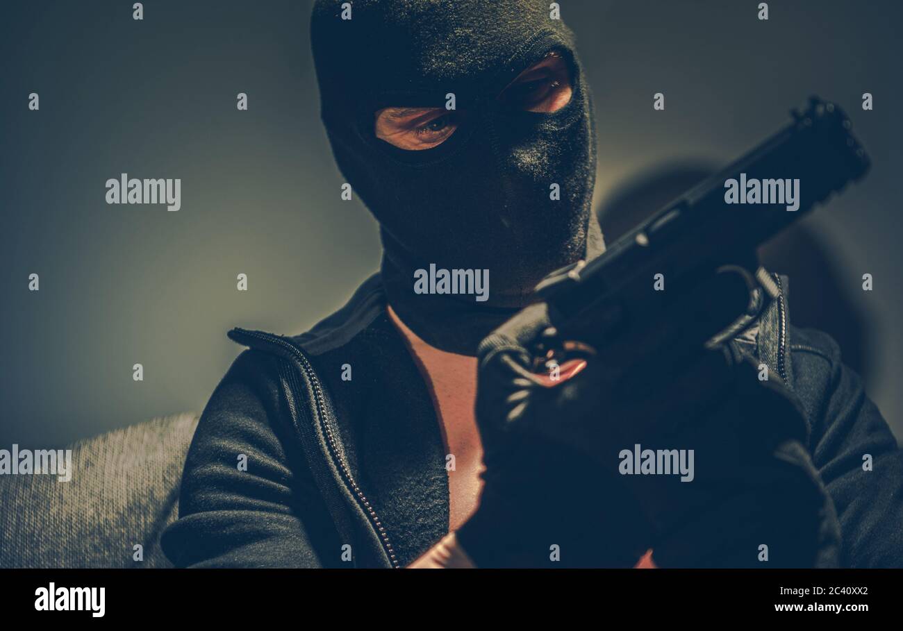 Dangerous Gangster with Hand Gun Wearing Balaclava Mask Preparing For Another Crime. Concept Photo. Stock Photo