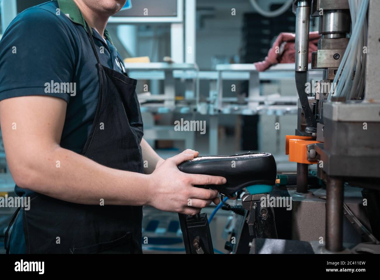 man working with automatic machinery on shoe factory Stock Photo