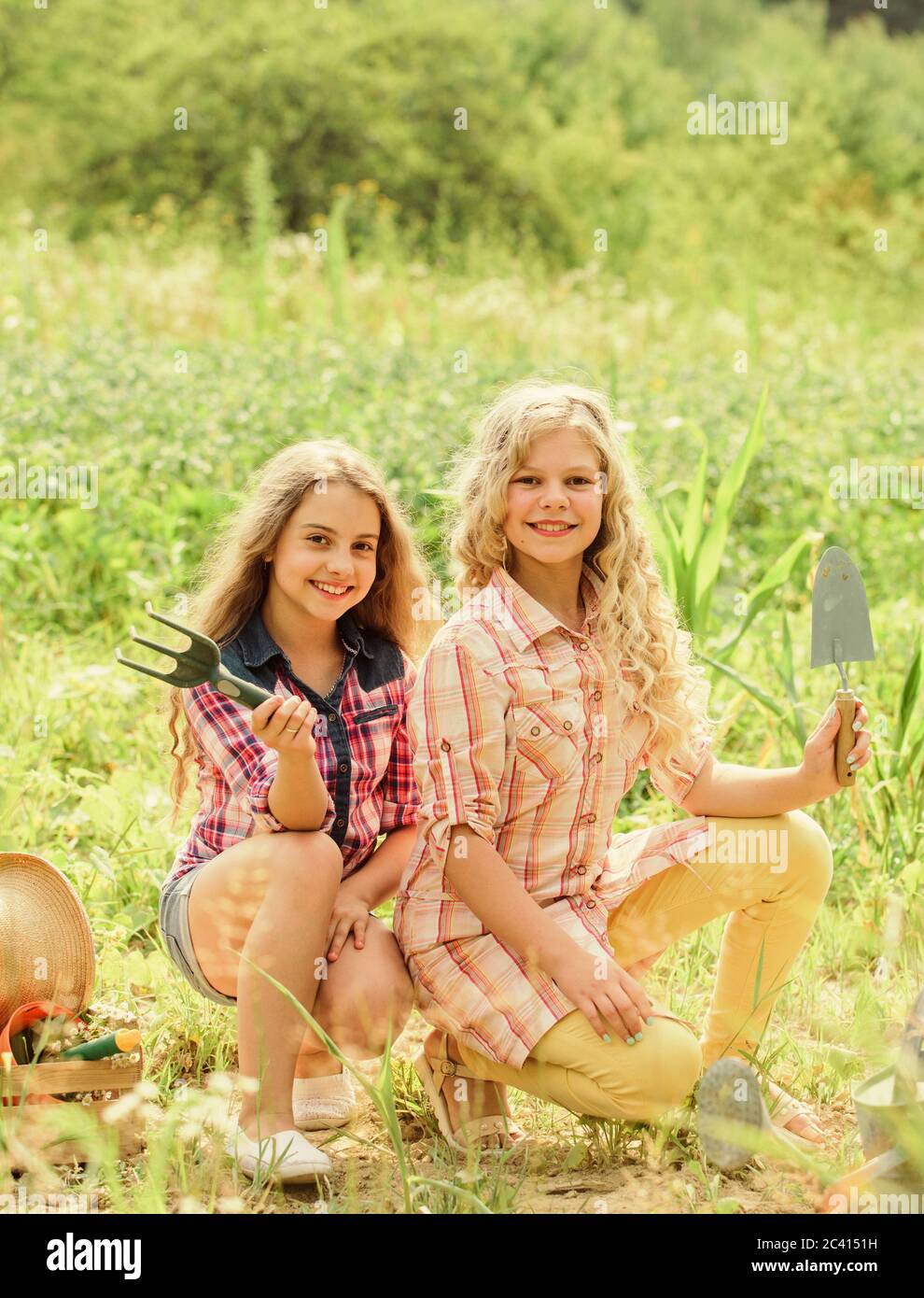 Sisters cute kids helping at farm. Girls planting plants. Planting and