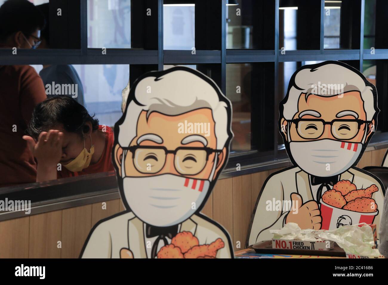 South Jakarta, Indonesia. 23rd June, 2020. Colonel Sanders' characters mounted at tables as a way of maintaining the social distance, a precaution against the spread of coronavirus (covid-19) at KFC. Credit: SOPA Images Limited/Alamy Live News Stock Photo