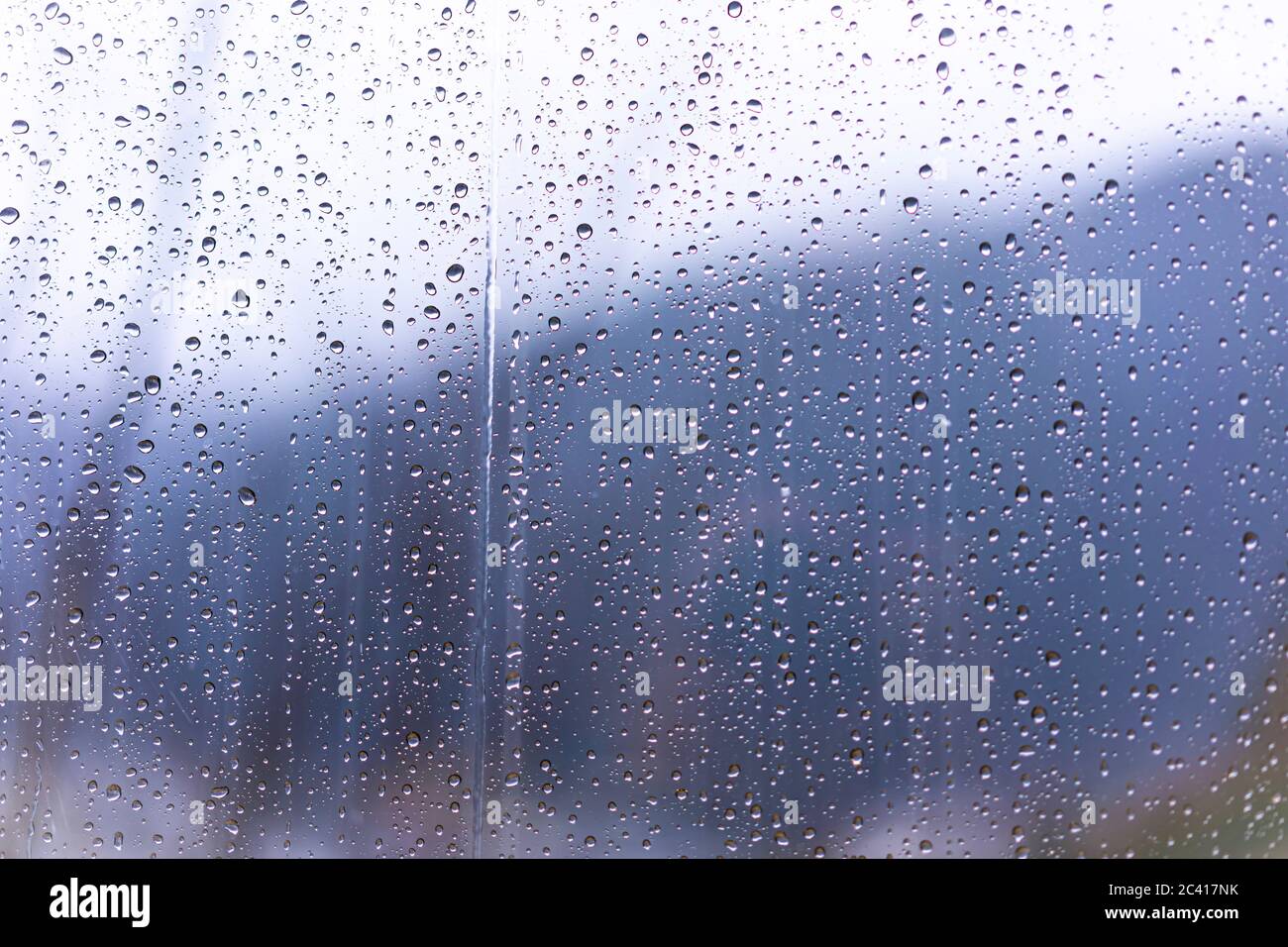 Raindrops on window glass with blur background Stock Photo