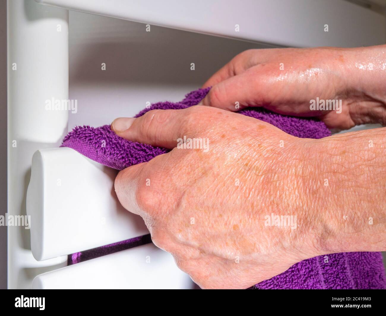 A man's wet hands after washing, reaching for a purple towel hanging over a  rail of a white bathroom radiator Stock Photo - Alamy