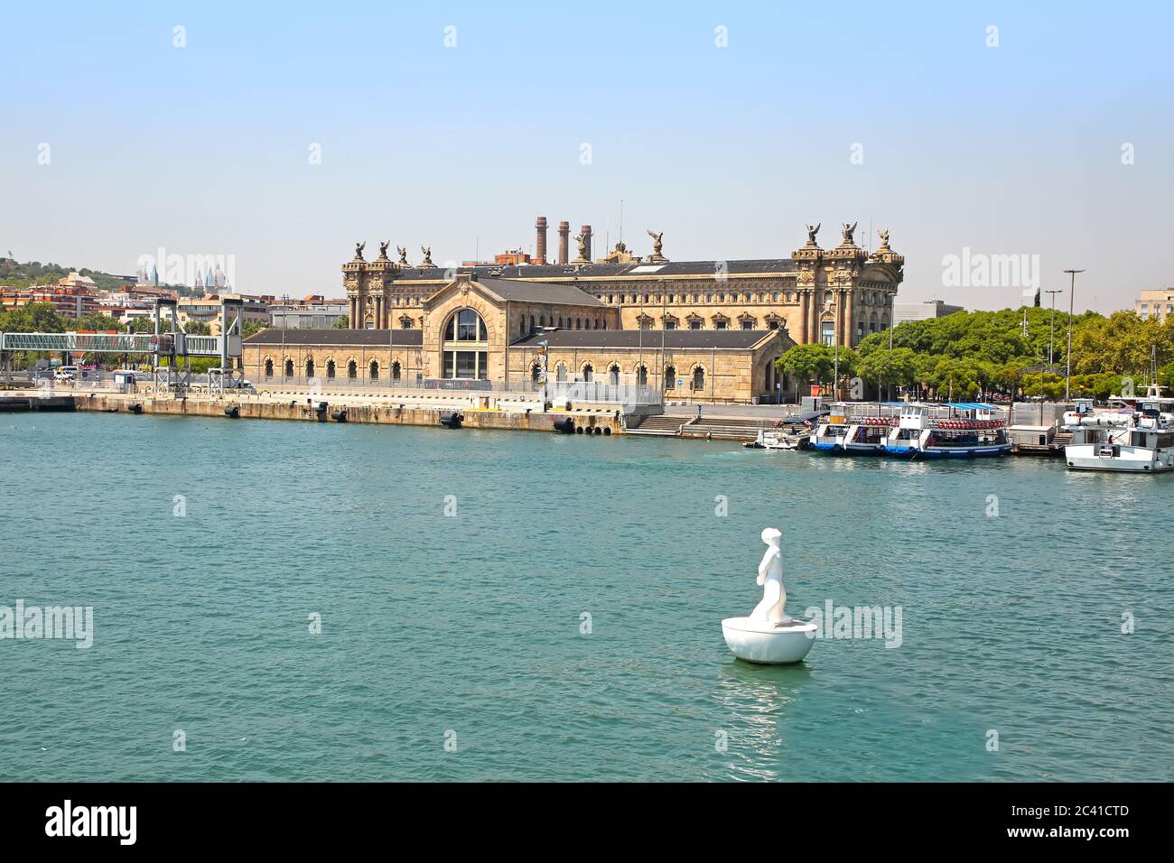 Harbour view towards the city including the Columbus Monument, floating Stargazer sculpture and old customs building, Port Vell, Barcelona, Spain. Stock Photo