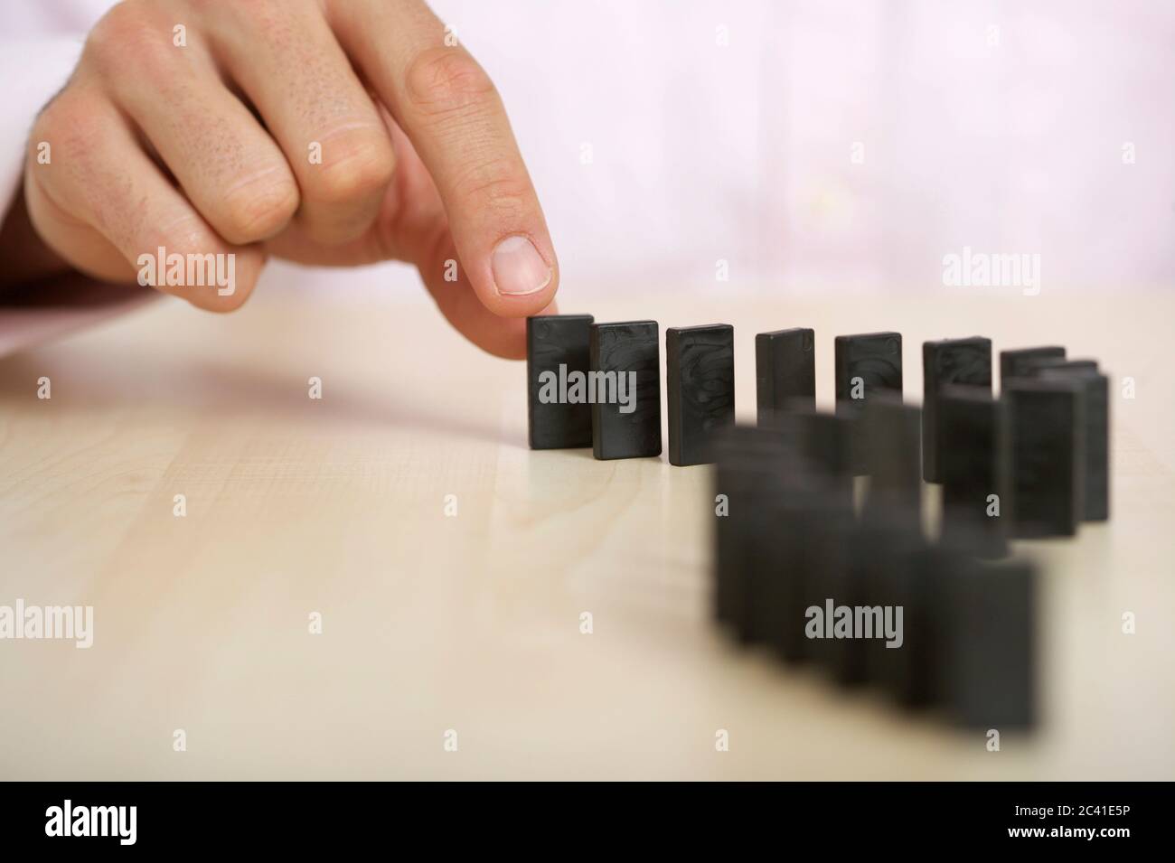 Hand puts dominoes on Stock Photo