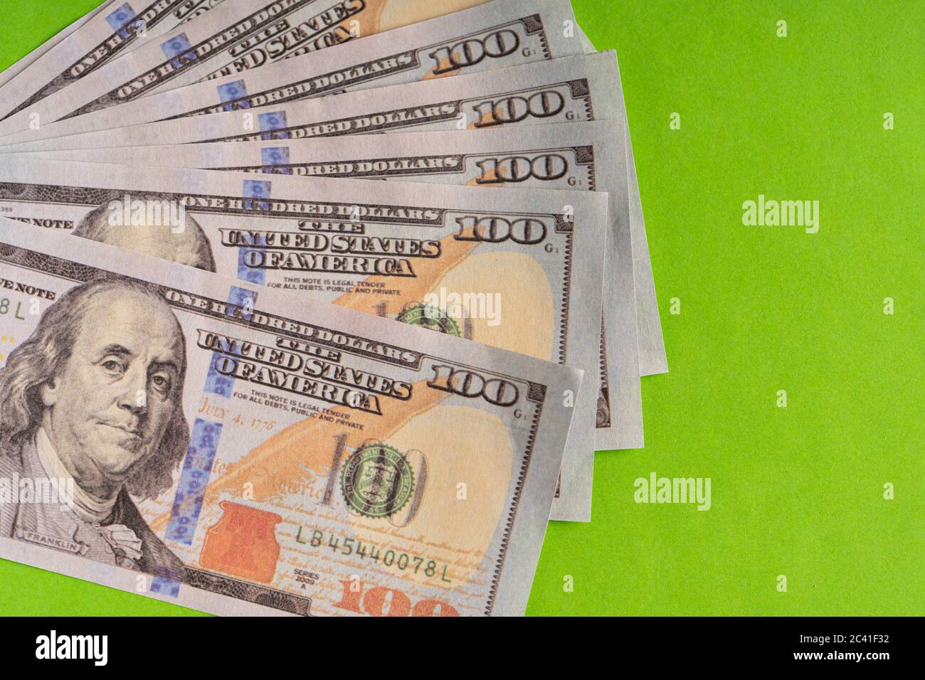 US Dollar bills against green background Stock Photo