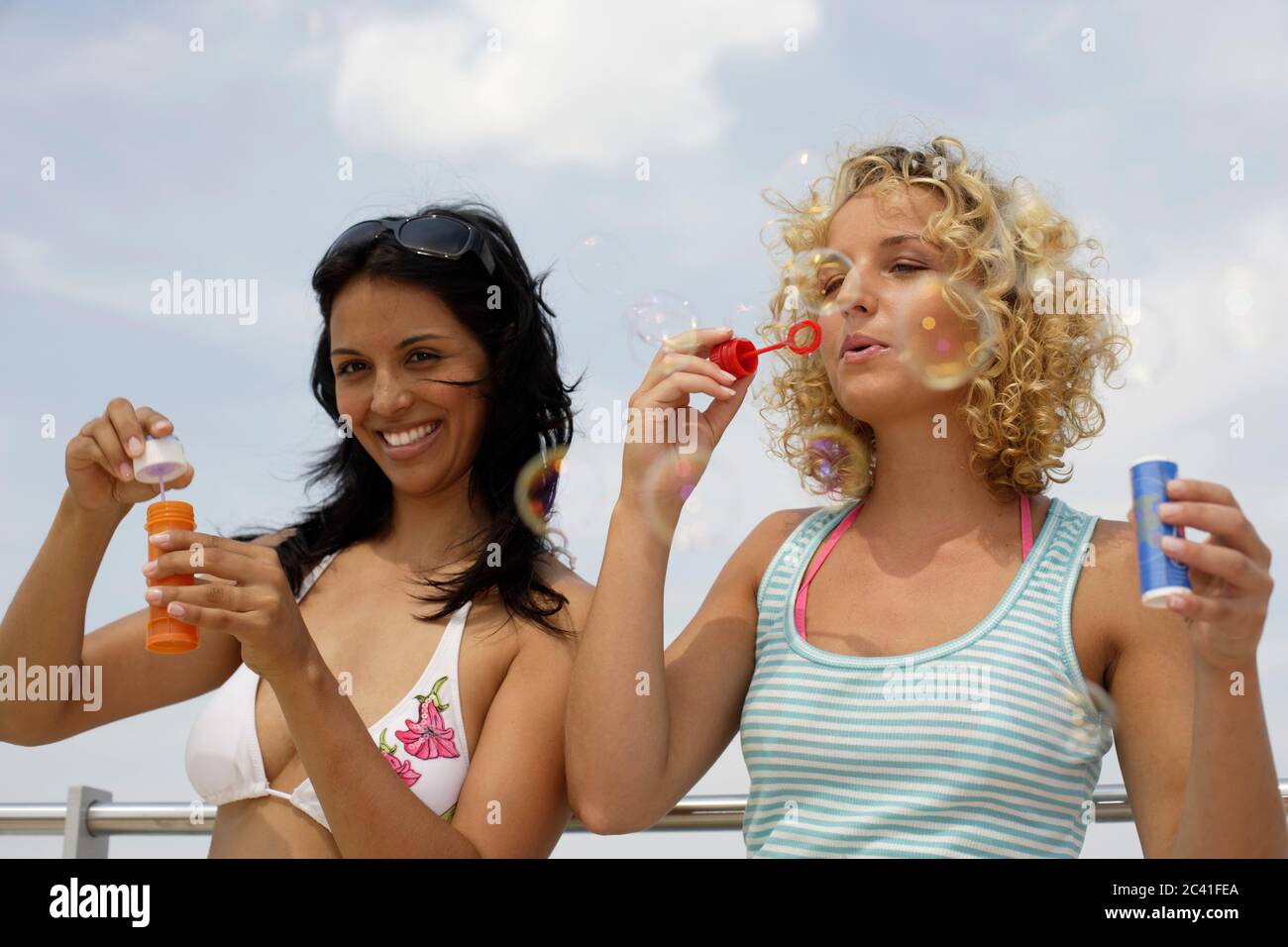 Two young women make soap bubbles girlfriends free time Stock Photo