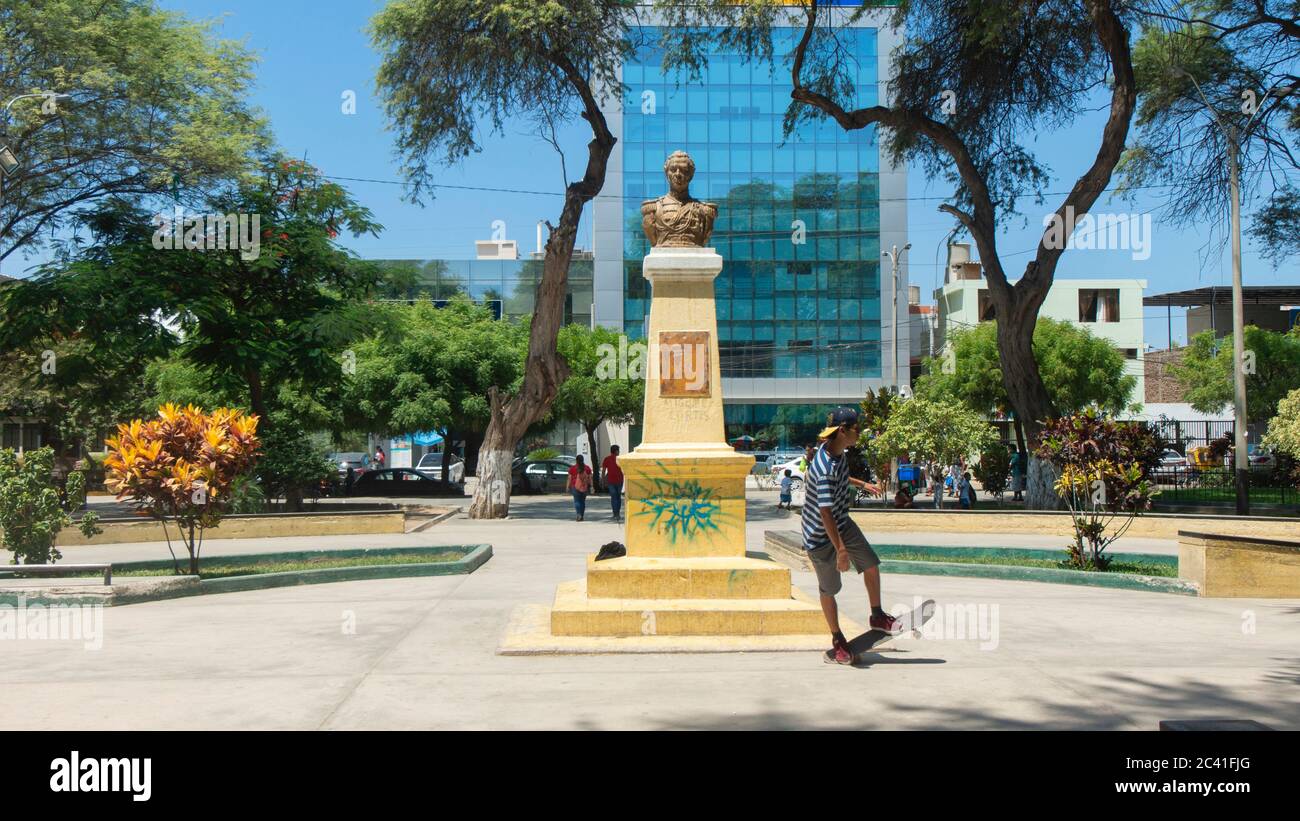 San Miguel de Piura, Piura / Peru - April 5 2019: Young man on skateboard next to the statue of Miguel Cortes in the center of the park Stock Photo
