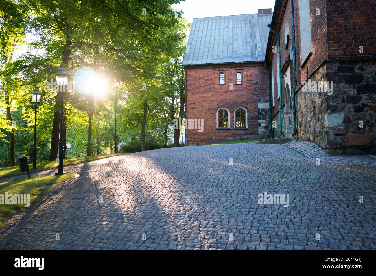 The sun is rising early in the morning. The old church yard is quiet and empty. Turku, Finland. Stock Photo