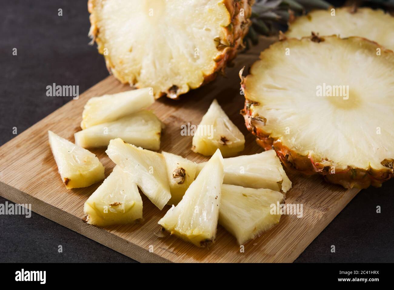 Fresh pineapple slices on black slate background Stock Photo