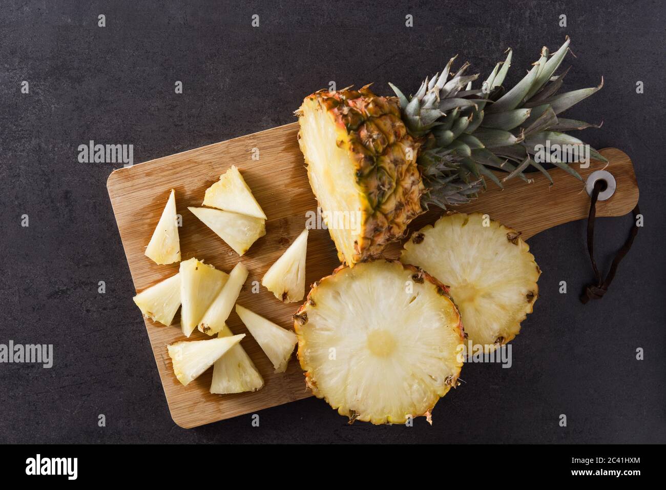 Fresh pineapple slices on black slate background Stock Photo