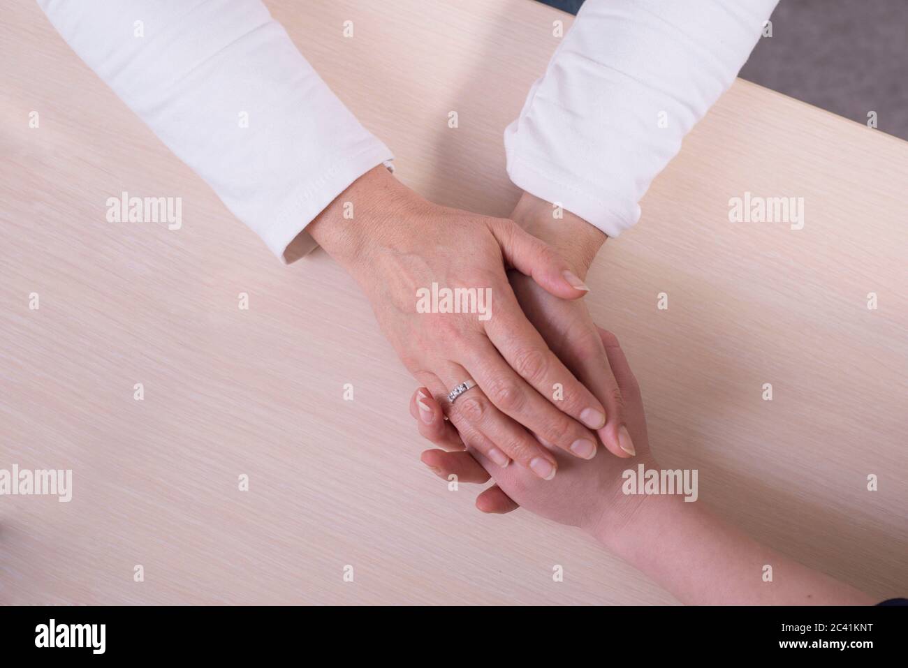 hands of an old woman touch the hands of a young girl, closeup. Psychological assistance, the doctor is a therapist, a psychologist takes the patient Stock Photo