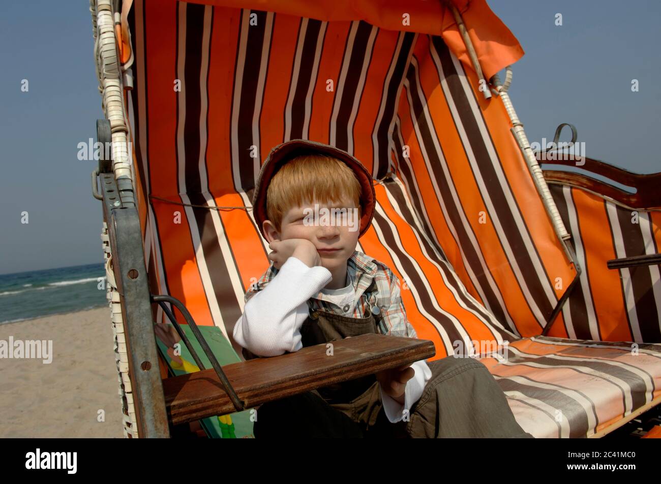 Boy with arm up in beach chair Stock Photo Alamy