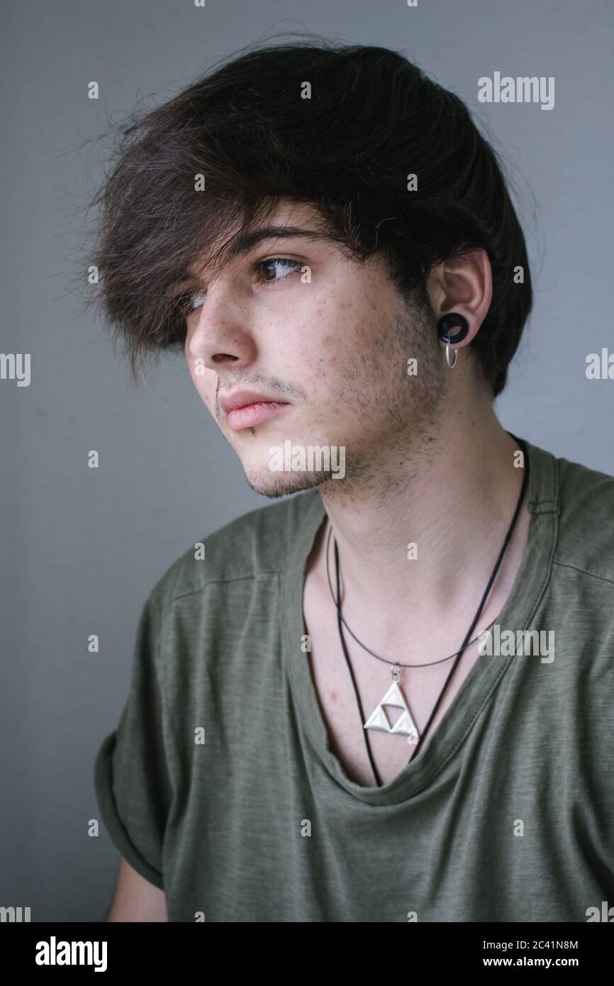 Portrait of a young boy with a necklace and earring. Stock Photo