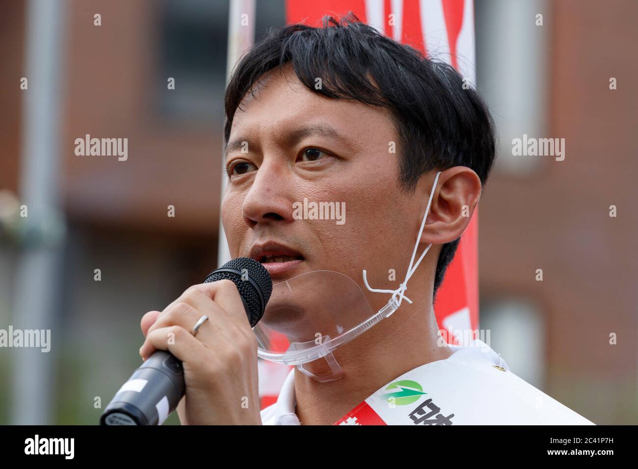 Tokyo, Japan. 23rd June, 2020. Candidate Taisuke Ono wears a mouth shield during his campaign speech for the Tokyo gubernatorial election outside Shimokitazawa Station. Ono, former vice governor of Kumamoto Prefecture, is campaigning for the Tokyo gubernatorial election, which will be held on July 5. Credit: Rodrigo Reyes Marin/ZUMA Wire/Alamy Live News Stock Photo