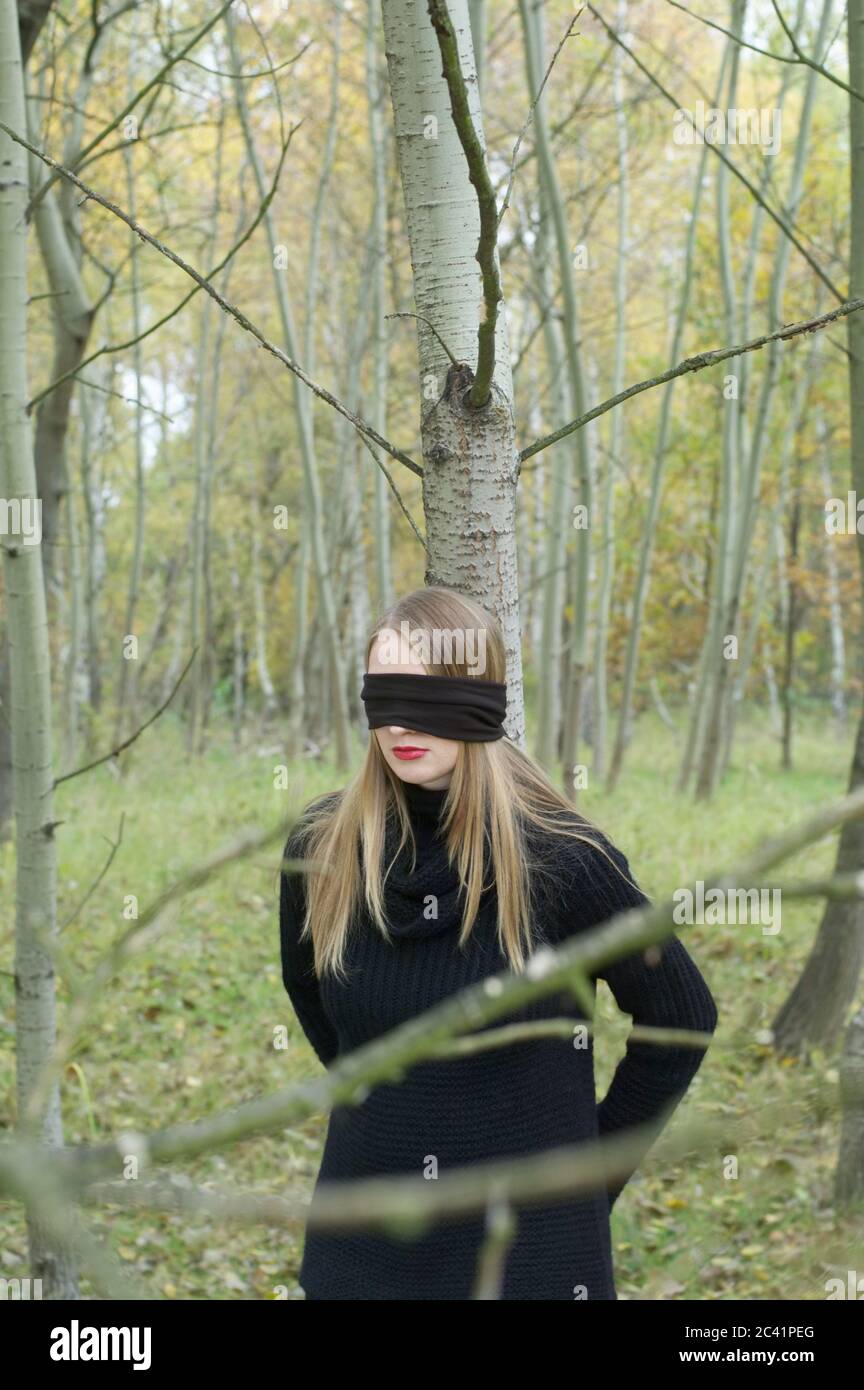 Young woman is tied up and blindfolded in the forest Stock Photo - Alamy