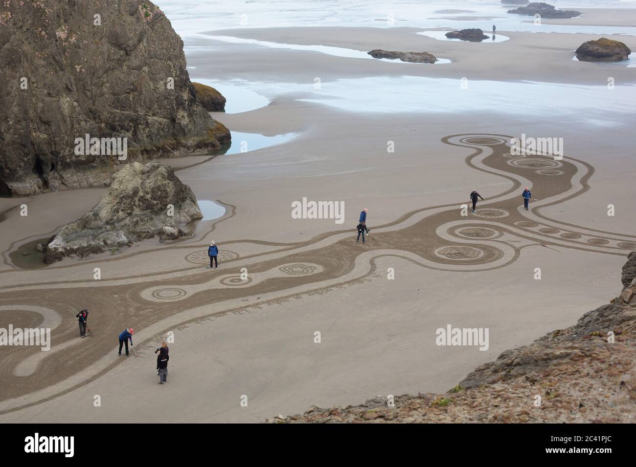 People walking a Circles in the Sand labyrinth at Face Rock Beach in Bandon, Oregon, USA. Stock Photo